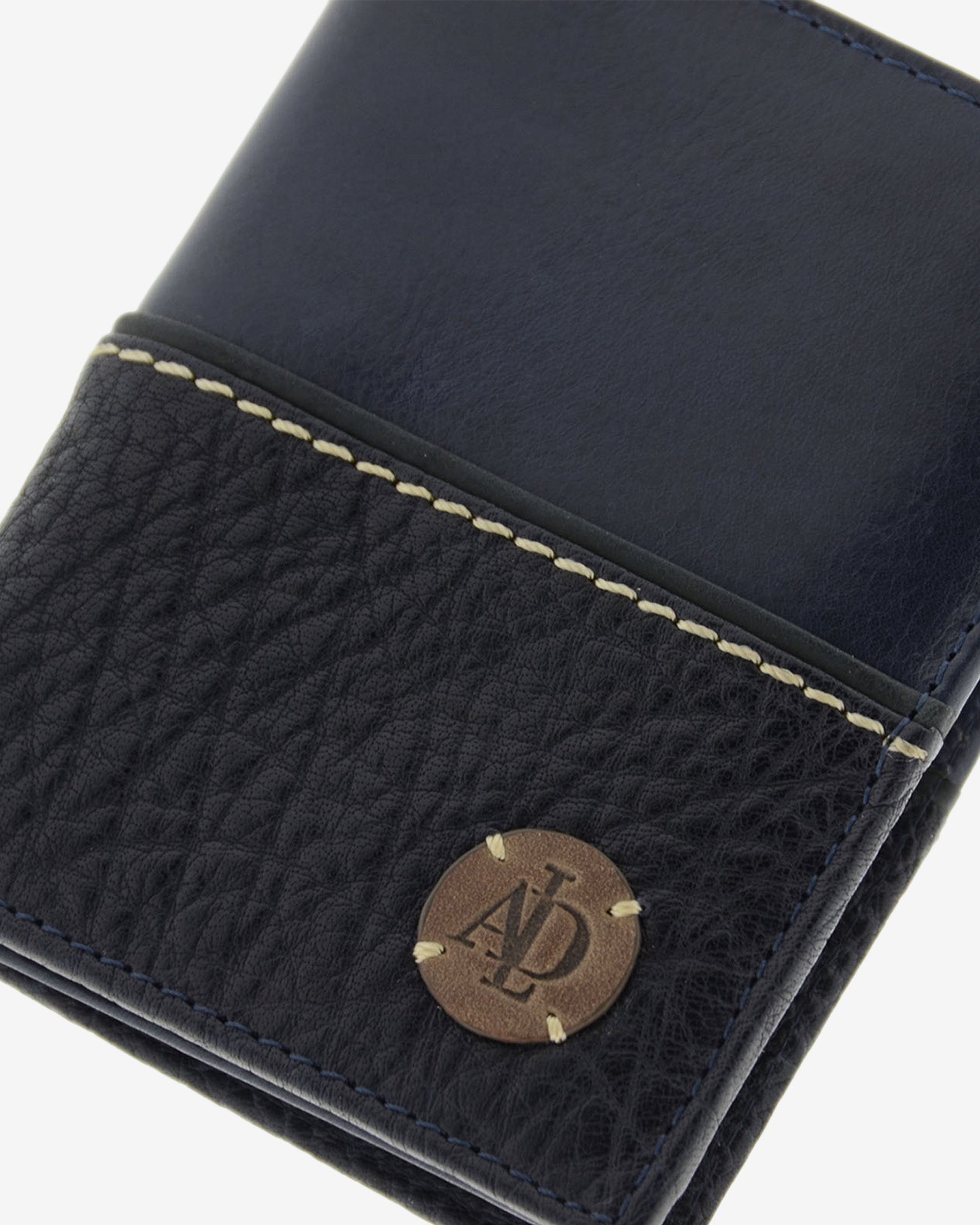 Detalle de cartera de hombre colección Rancho en piel rústica de color marino con logo circular Adapell grabado y cosido, y costura decorativa contrastada. Ref. 1605-20