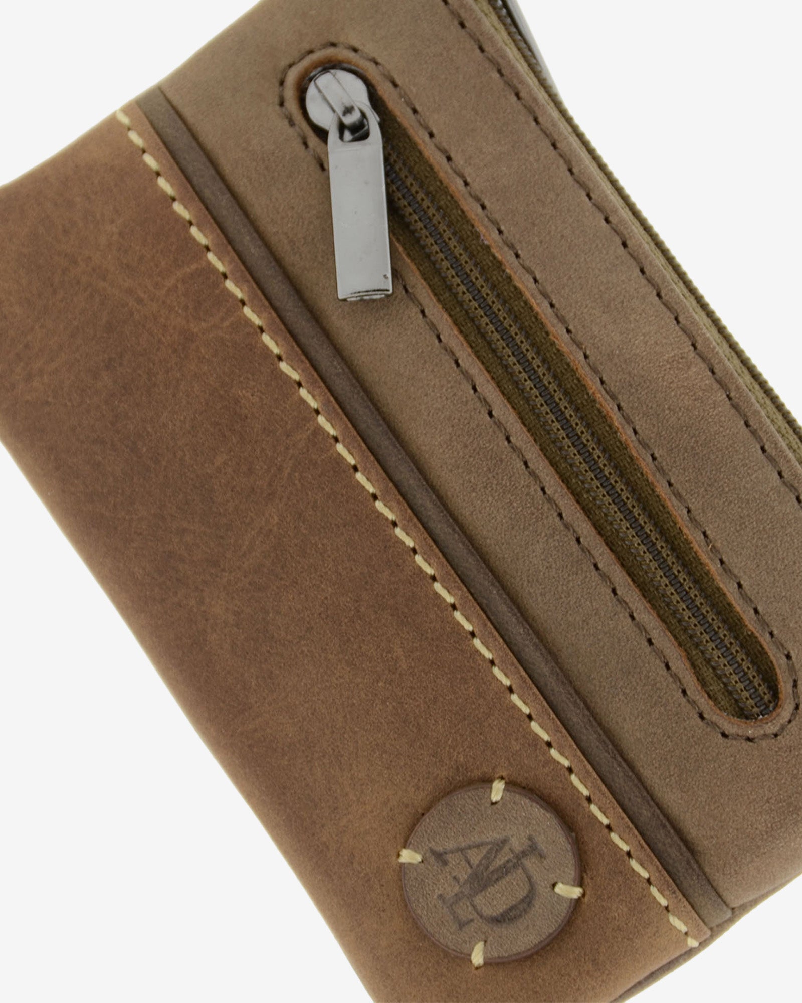 Detalle del monedero de la colección Rancho en piel rústica bicolor marrón con costura decorativa, bolsillo frontal con cremallera y logo circular Adapell. Ref. 1608-2