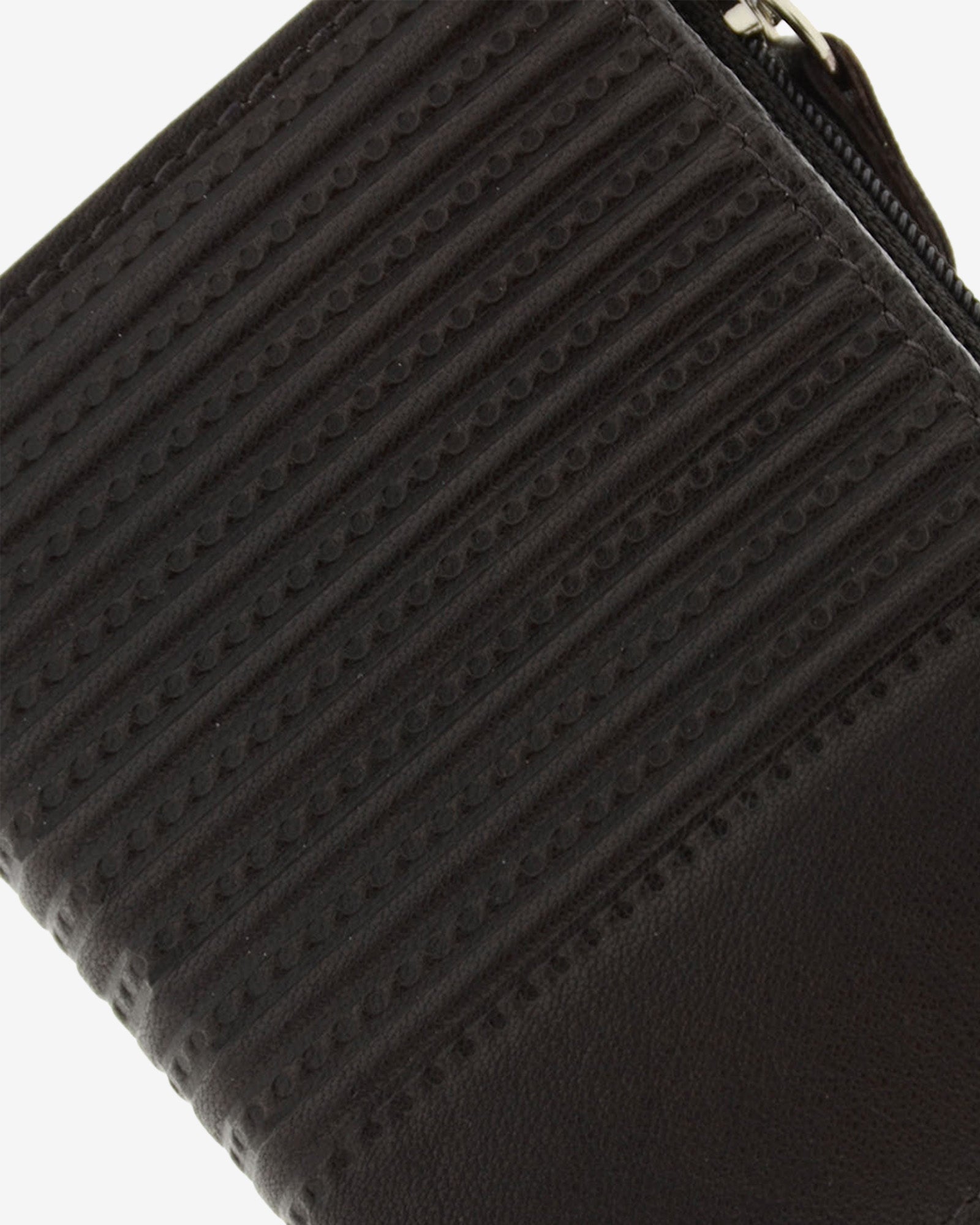 Detalle del grabado lineal en piel marrón de cartera vertical ultrafina