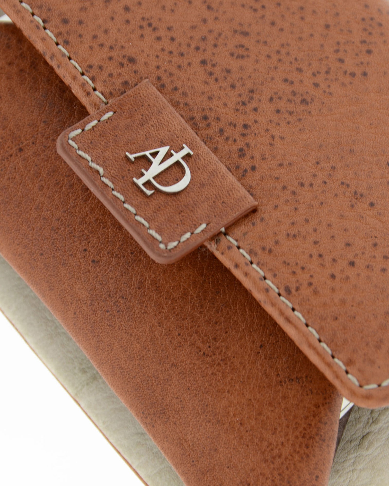 Detalle del monedero con boquilla interior Adapell 4234 en color marrón, con textura de la piel, pespuntes y logo metálico.