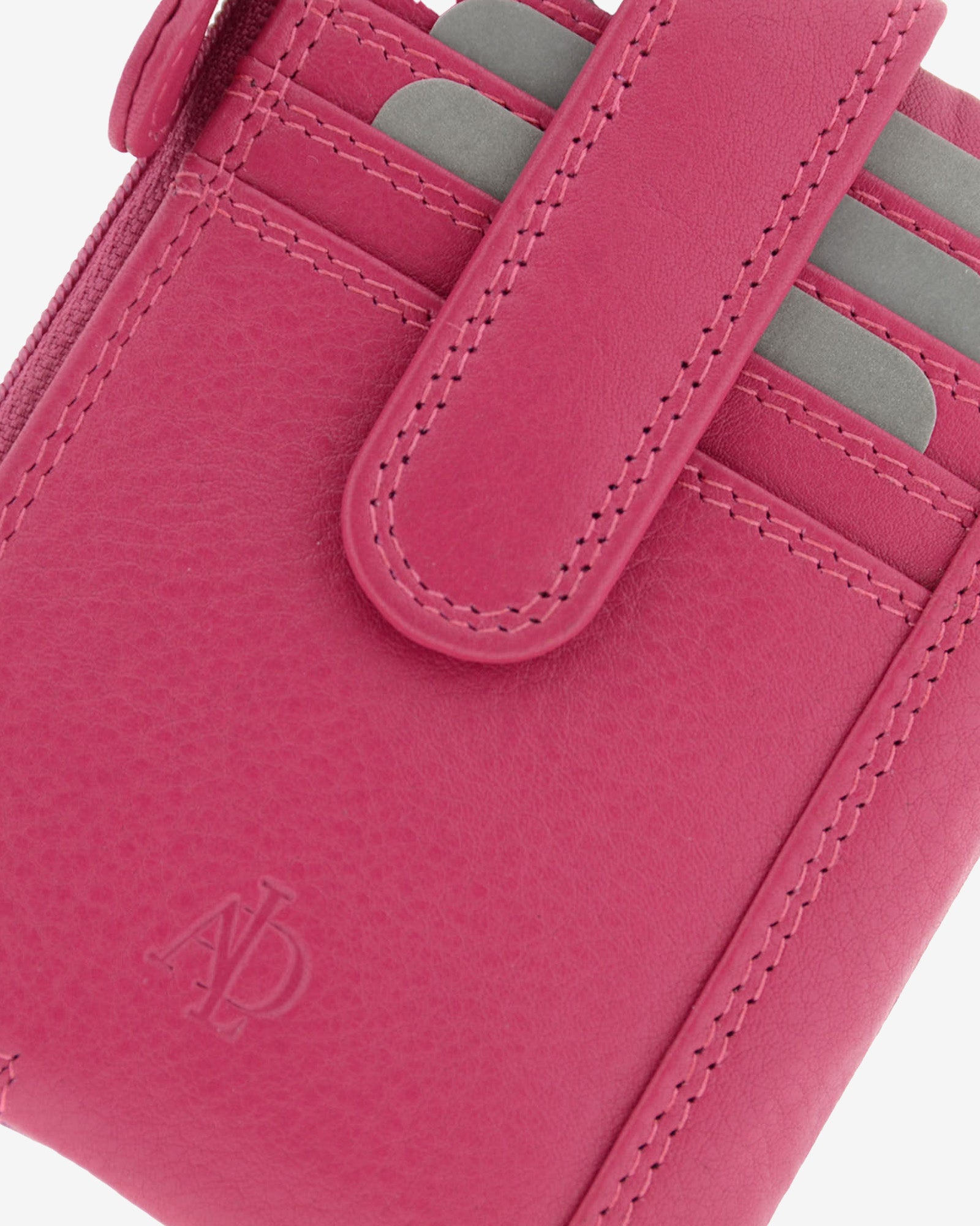 Detalle de la piel, la lengüeta, las costuras y las ranuras para tarjetas del monedero tarjetero 8036 en color magenta.