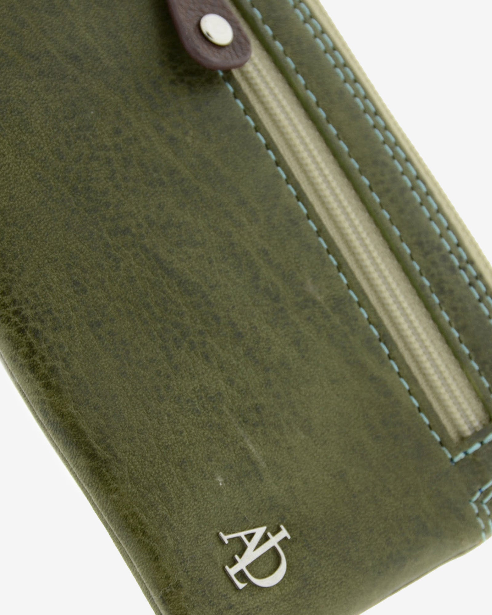 Detalle frontal del monedero fino de piel verde 8053-V, con bolsillo frontal con cremallera, costuras y logo metálico.