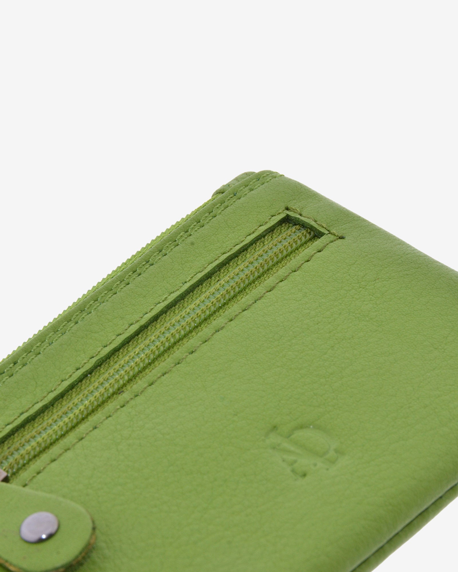 Detalle de la textura de la piel, las costuras, la cremallera frontal y el logo del monedero 8010 en color Matcha.