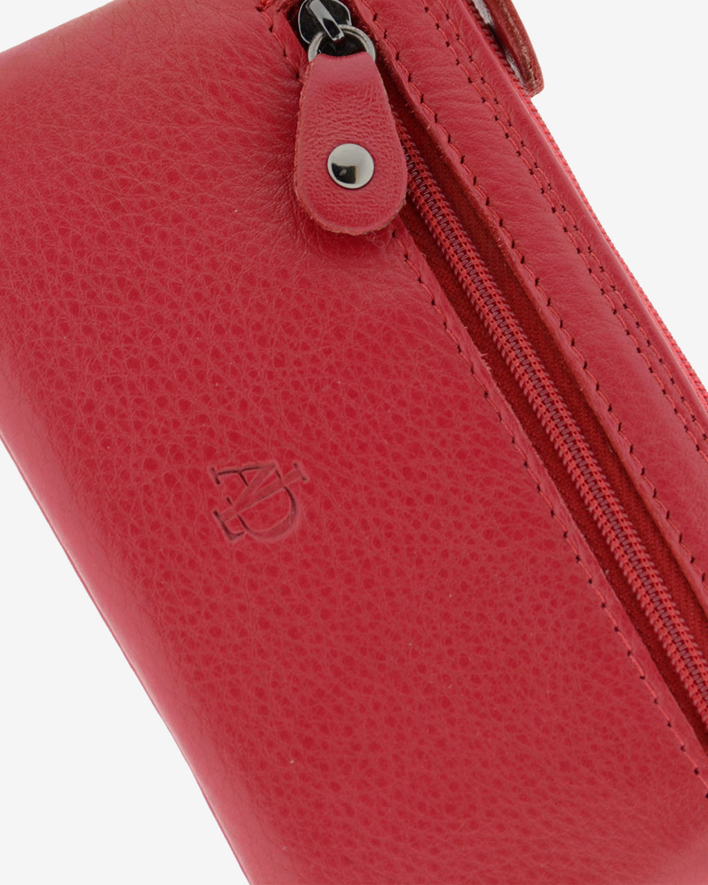 Detalle de la textura de la piel, el logo grabado y la cremallera frontal del monedero 8079 en color rojo.