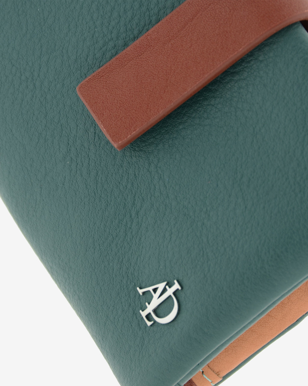 Primer plano de la cartera Brisa en color Ocean Teal mostrando la textura de la piel, la tira de cierre en contraste y el logo metálico Adapell.