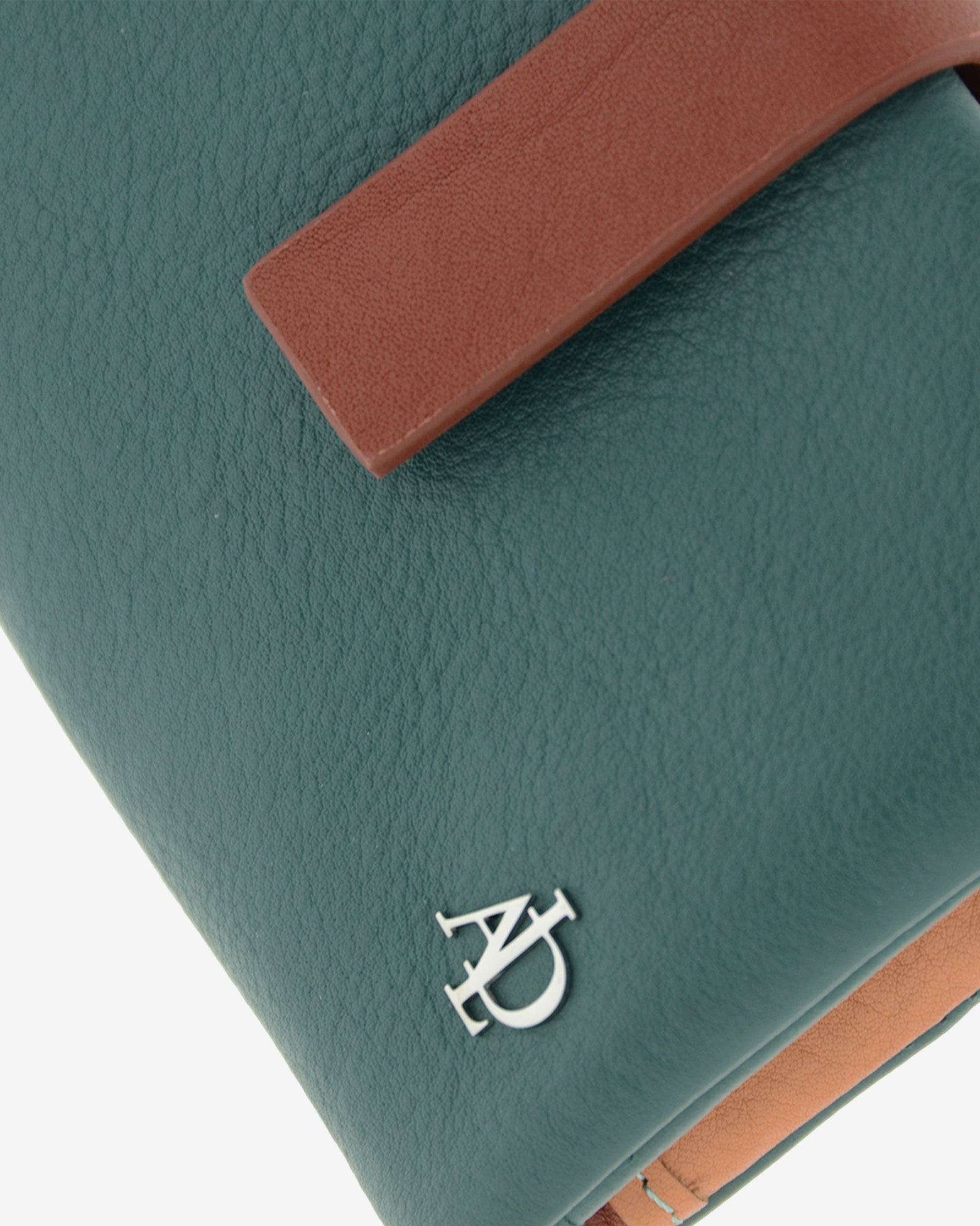 Primer plano de la cartera Brisa en color Ocean Teal mostrando la textura de la piel, la tira de cierre en contraste y el logo metálico Adapell.
