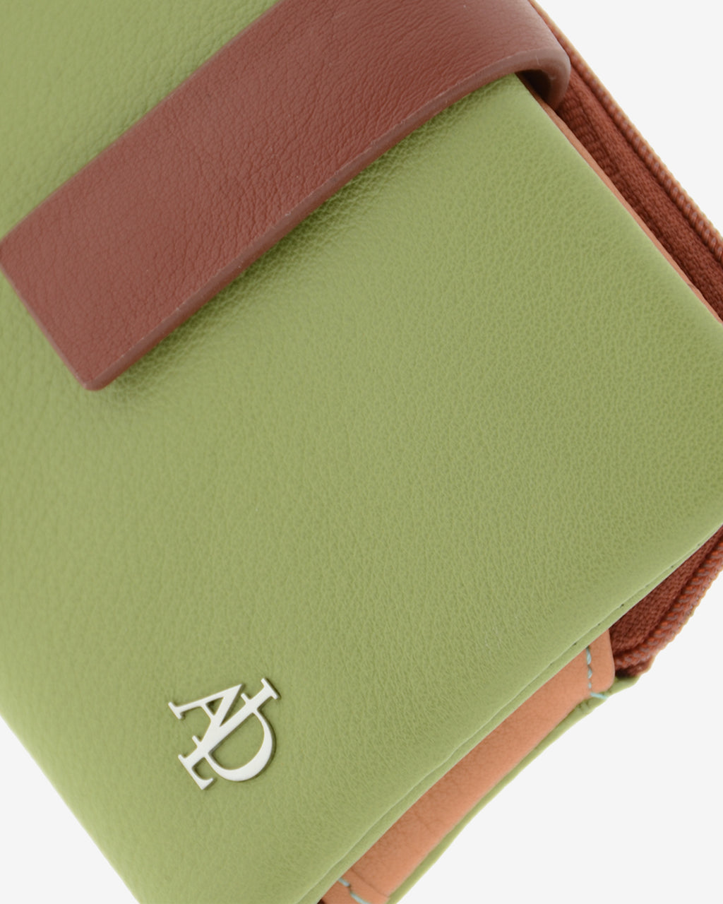 Primer plano de la cartera Brisa en color Verde Sage mostrando la textura de la piel, la tira de cierre en contraste y el logo metálico Adapell.