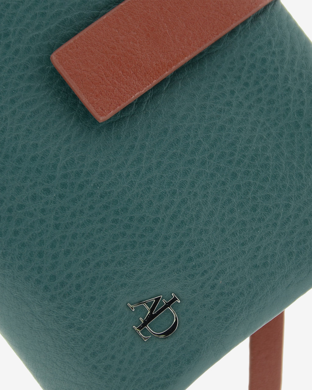 Detalle del logo metálico y la textura de la piel en la cartera pequeña de mujer Brisa color Ocean Teal.