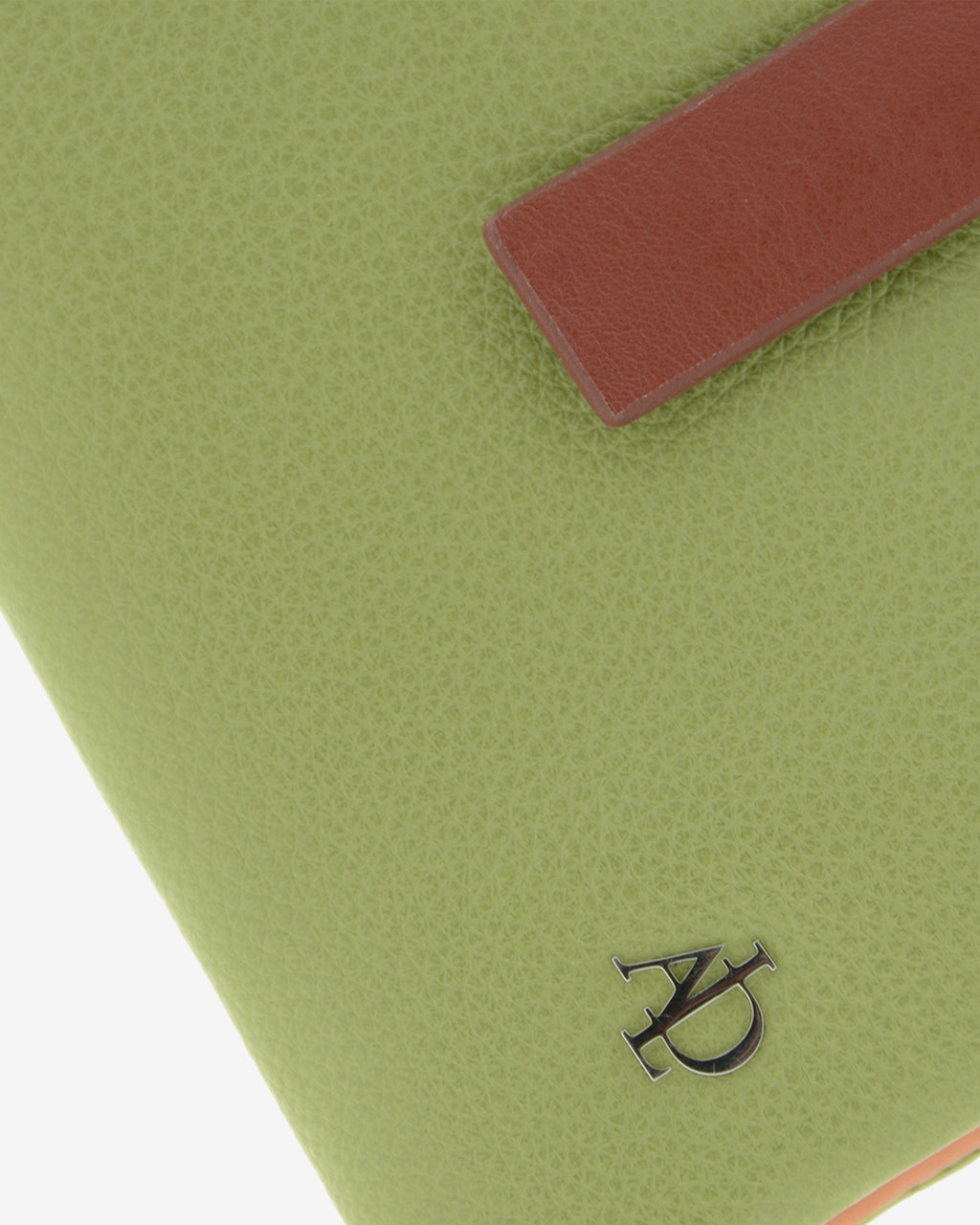 Detalle del logo metálico y la textura de la piel en la cartera pequeña de mujer Brisa color verde Sage.