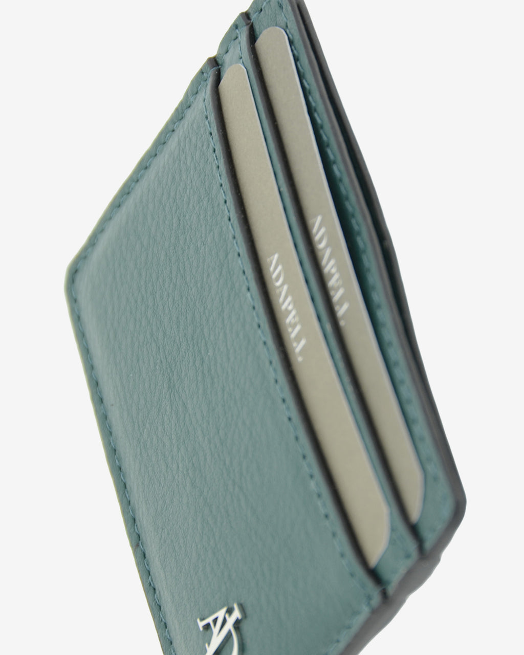 Detalle de las ranuras para tarjetas, la textura de la piel y el logo metálico Adapell del tarjetero Brisa en color Ocean Teal.