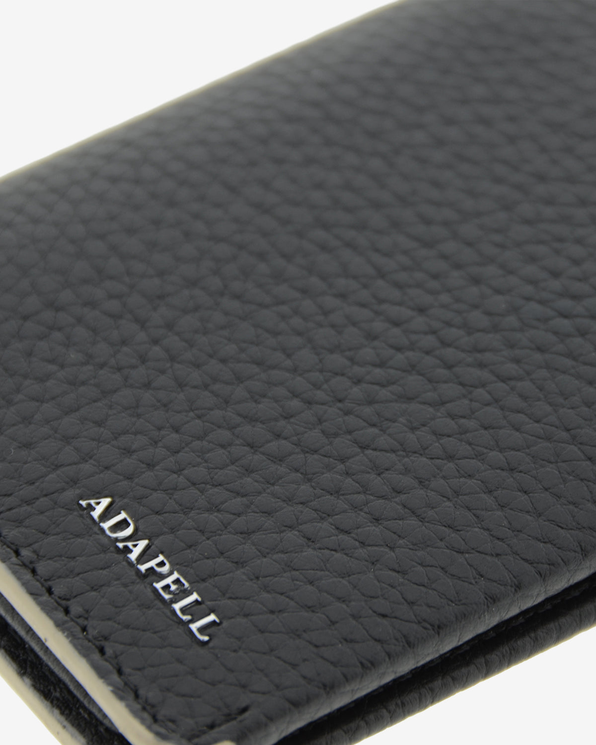 Primer plano de la piel granulada y el logo ADAPELL de la cartera vertical Nexo 1670 negra.