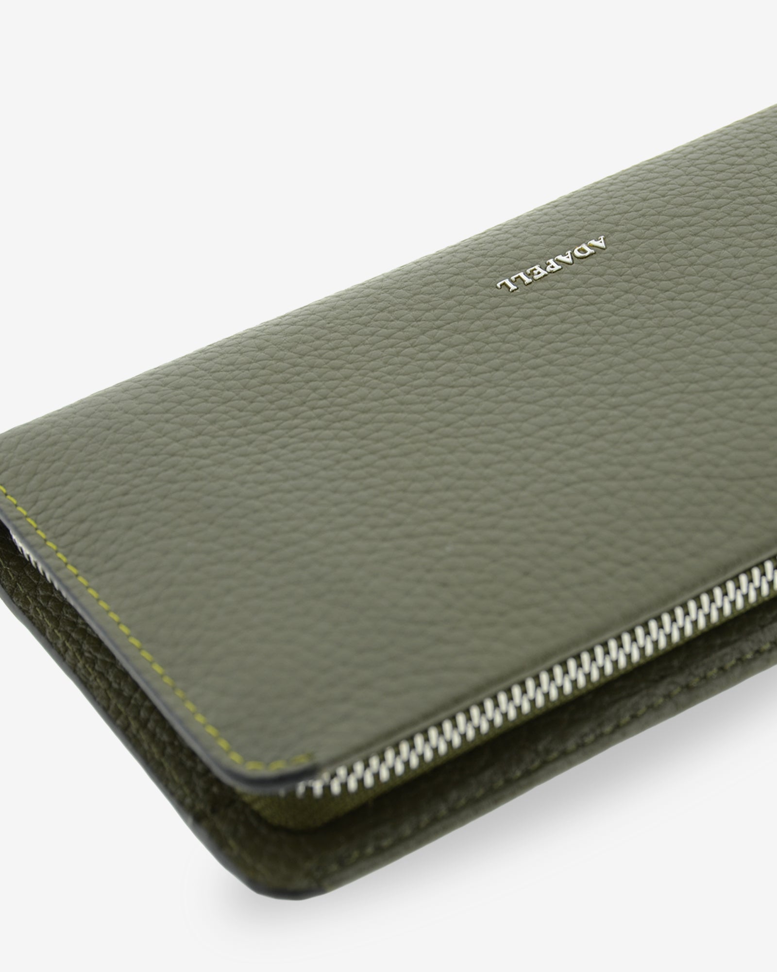 Primer plano de la piel granulada, el logo ADAPELL y la cremallera de la cartera Nexo 4260 Verde Loden.