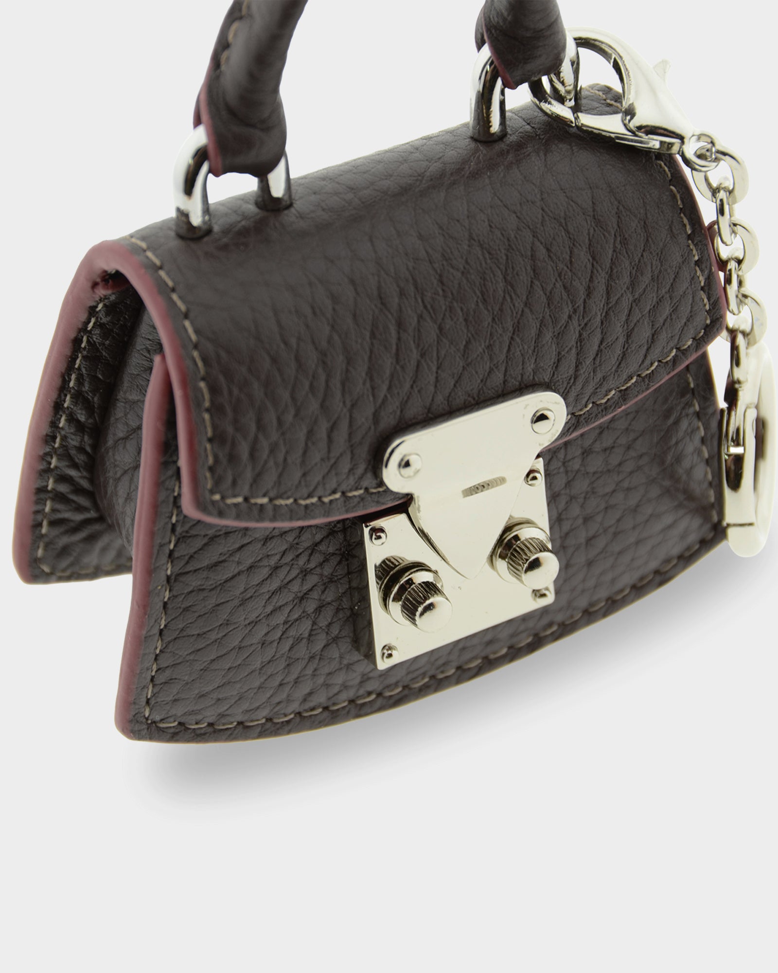 Detalle frontal del charm para bolso con funda para auriculares Nexo 8099 chocolate con solapa y cierre metálico