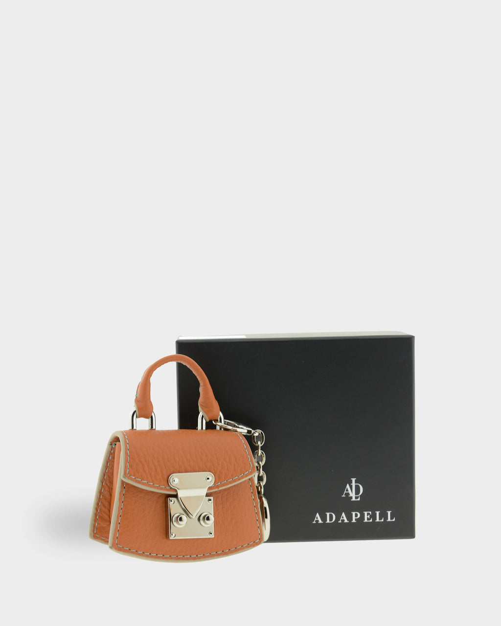 Charm para bolso con funda para auriculares Nexo 8099 miel presentado junto a la caja Adapell