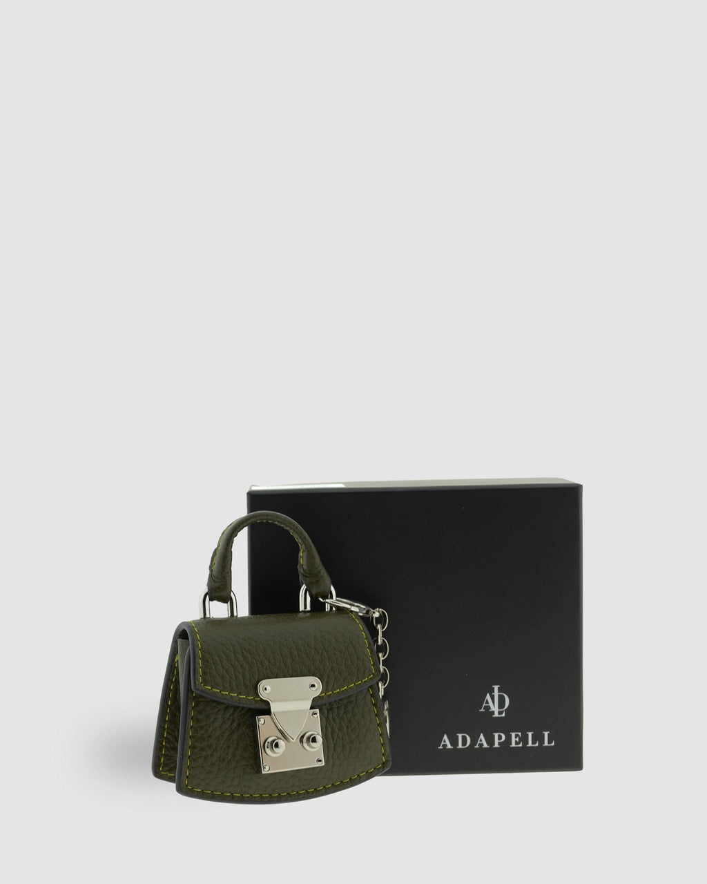 Charm para bolso con funda para auriculares Nexo 8099 verde Loden presentado junto a la caja Adapell