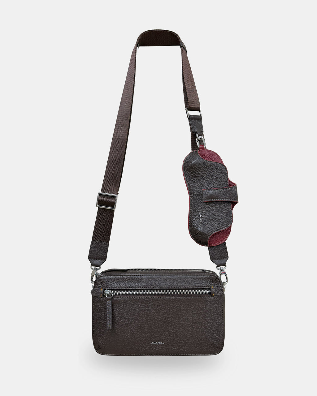 Bolso bandolera horizontal Nexo chocolate con bandolera textil regulable y accesorio acoplable, colocado para llevar al hombro o cruzado