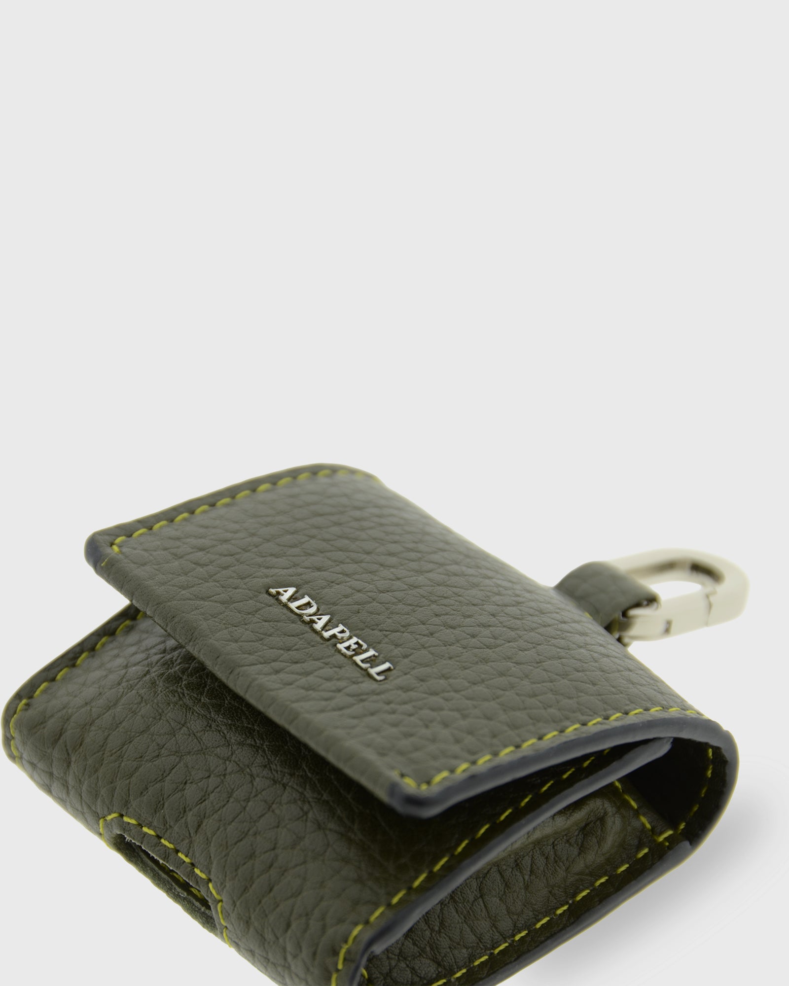 Detalle ampliado de la funda para auriculares Nexo 8093 verde Loden con solapa parcialmente abierta, piel granulada y anilla metálica