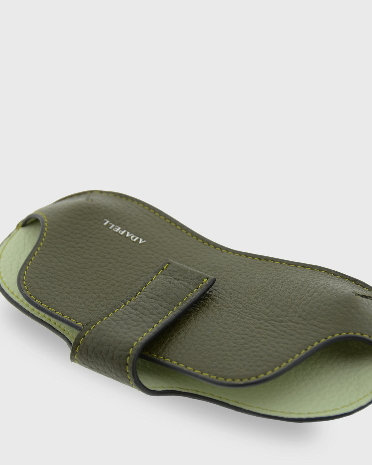 Detalle frontal de la funda para gafas Nexo 8094 verde Loden en posición horizontal, mostrando la piel granulada, la tira de sujeción y el logo Adapell
