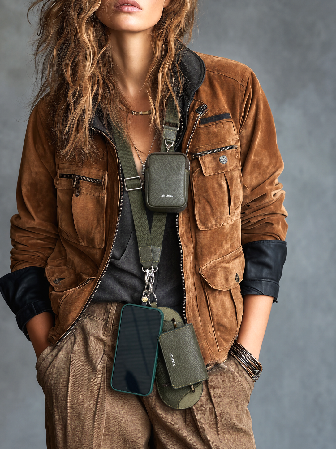 Mujer llevando el lanyard Nexo ajustable para móvil en color verde Loden, colgado del cuello, con accesorio Nexo compatible y teléfono colgando.