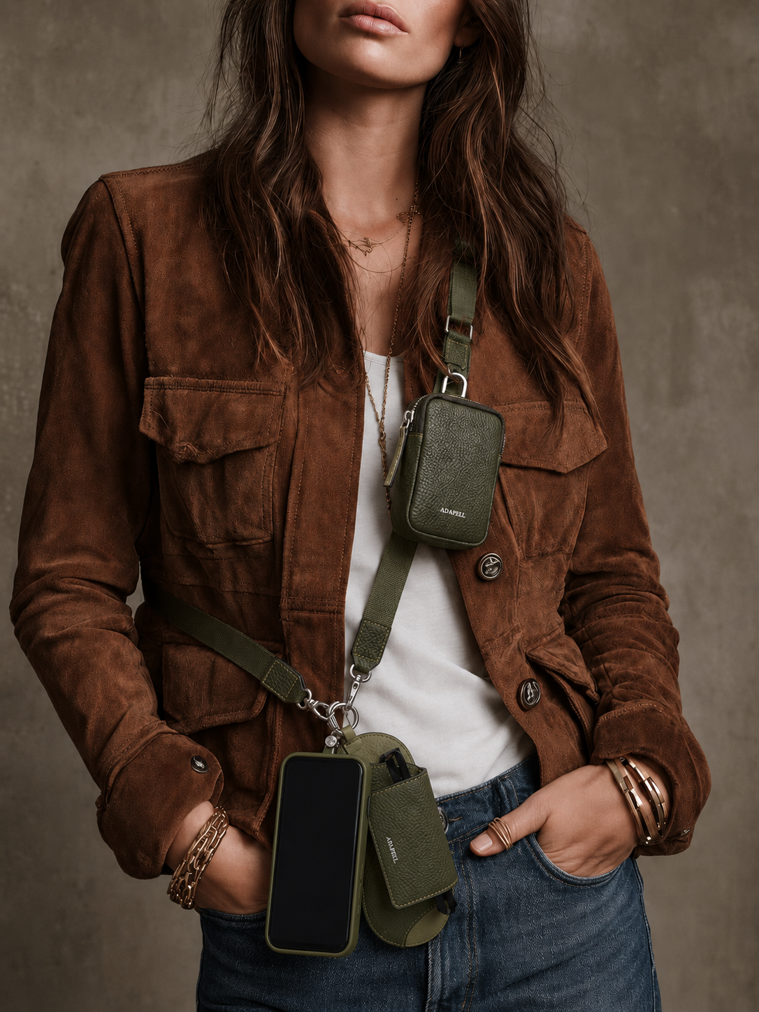 Mujer llevando el lanyard Nexo ajustable para móvil en color verde Loden, colgado cruzado, con accesorio Nexo compatible y teléfono colgando.