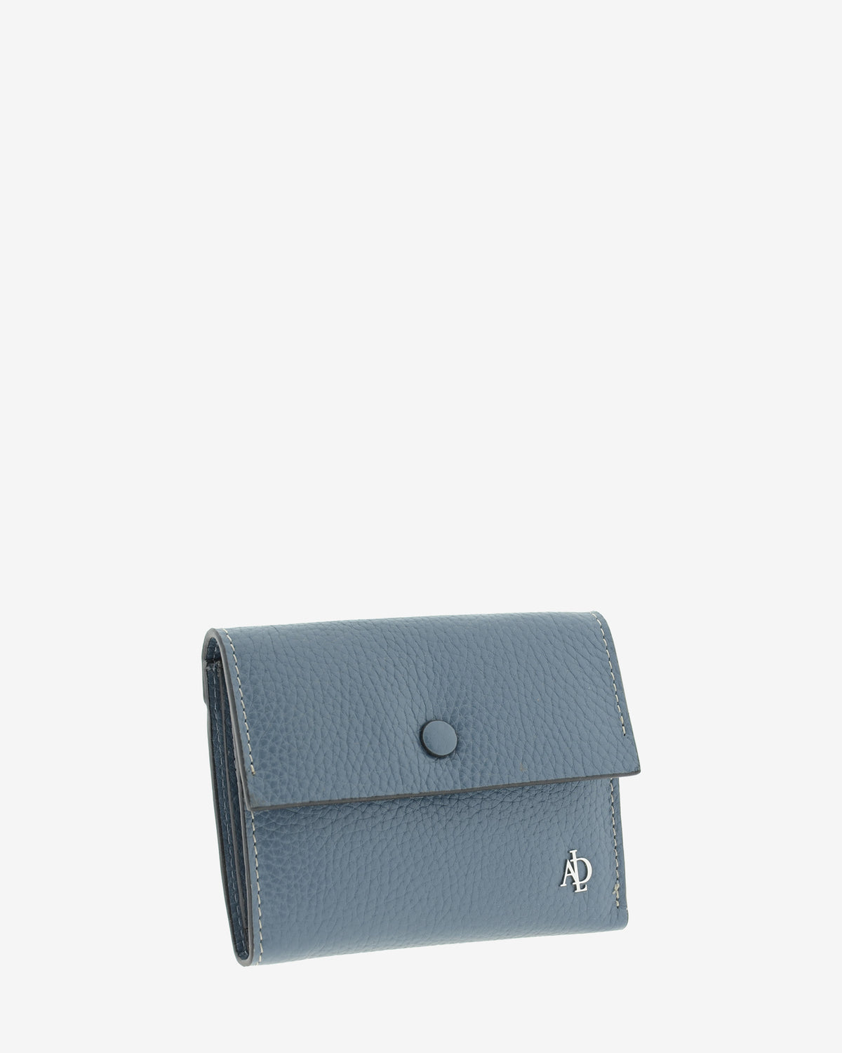 Cartera pequeña de mujer Nude en color Azul piedra, vista frontal en tres cuartos con solapa y botón a presión.