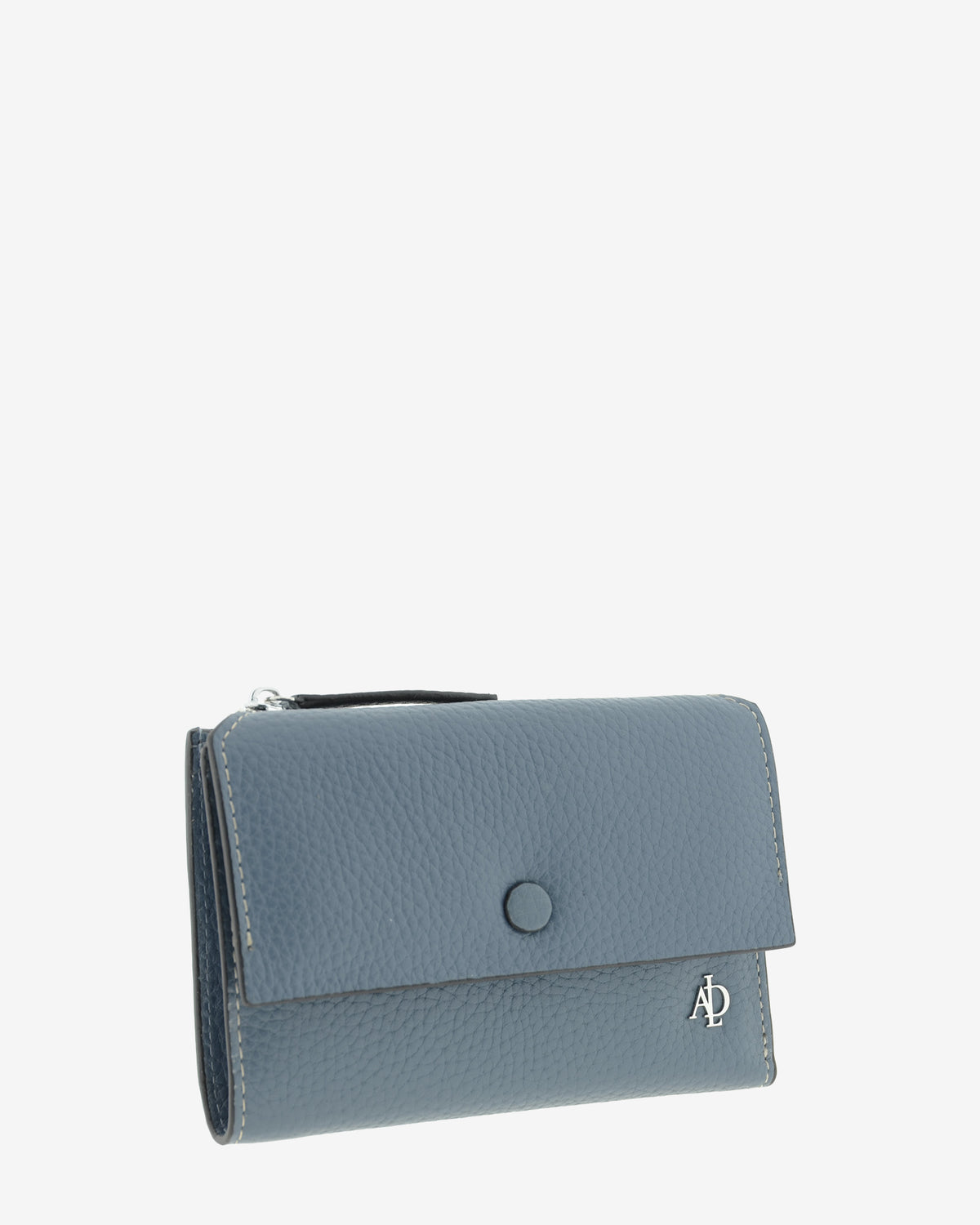 Cartera pequeña de mujer Nude en color Azul Piedra, vista frontal en tres cuartos con solapa y botón a presión.