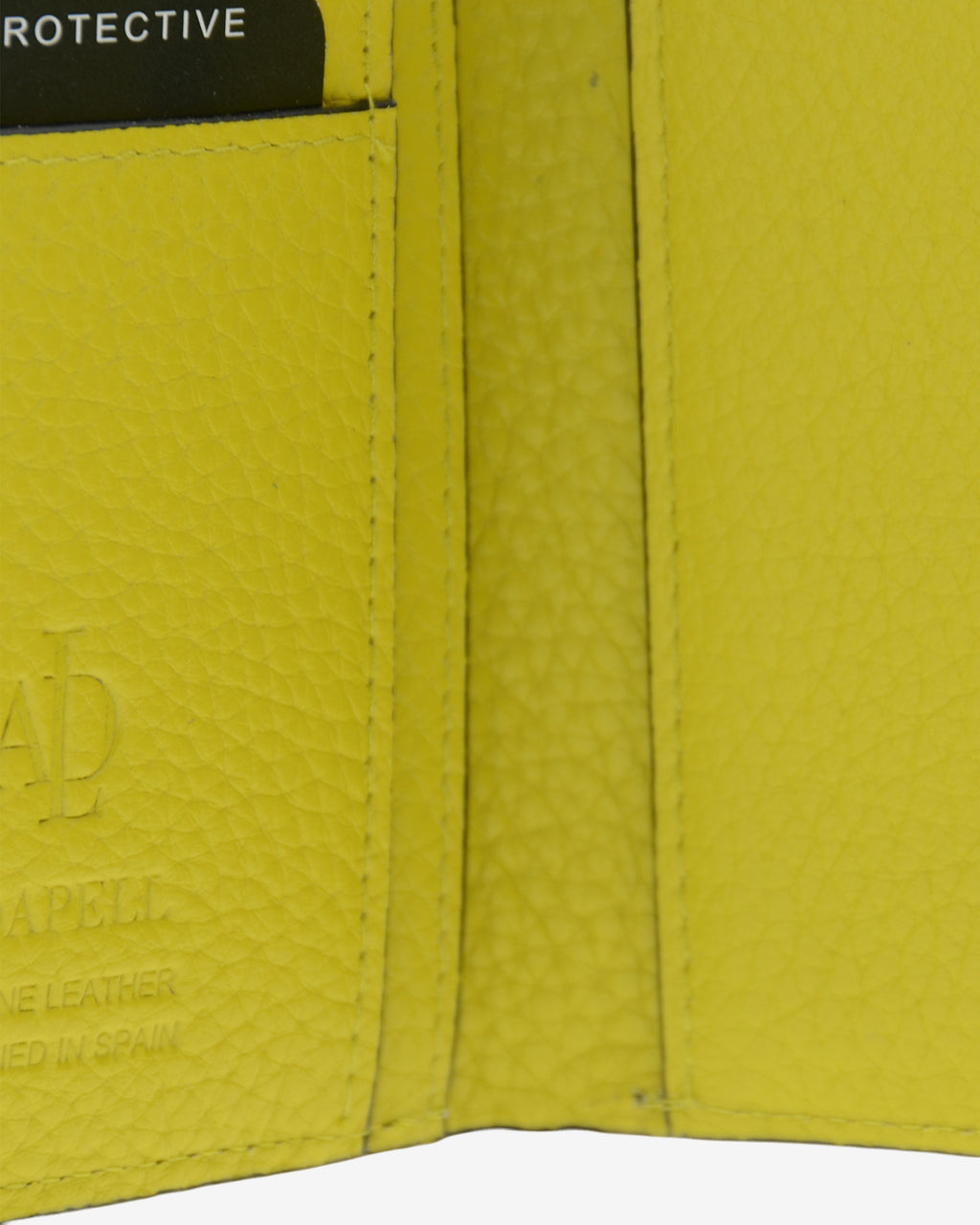 Detalle interuior de la cartera, la textura de la piel y el logo metálico Adapell de la cartera Nude en color Citrine.