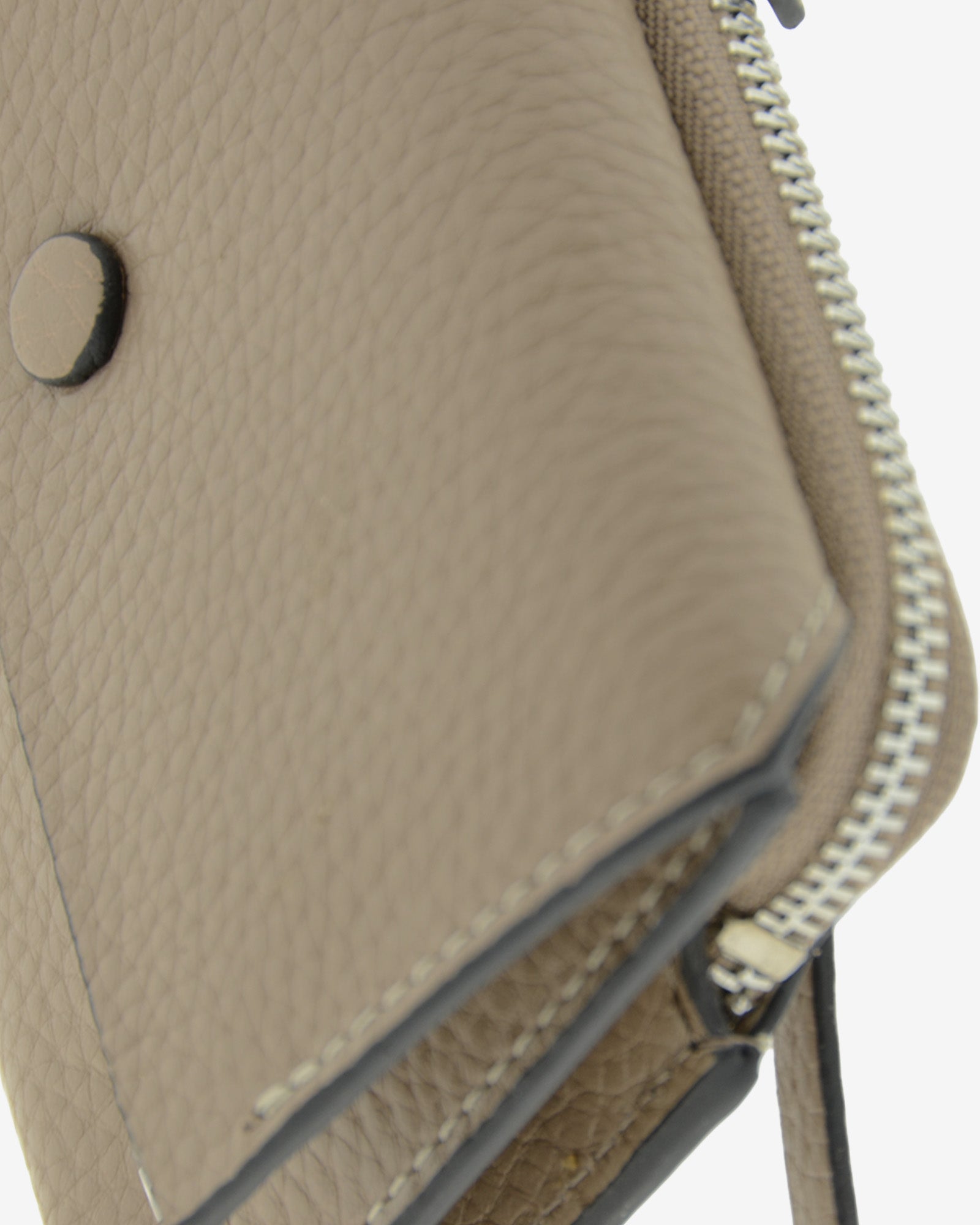 Detalle de la cartera pequeña Nude en color Topo, con solapa, costuras y cremallera visibles.