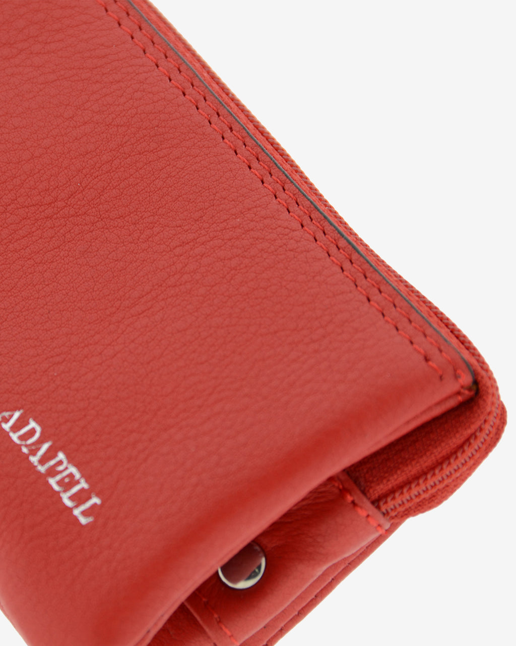 Monedero de piel auténtica ref. 8082-1 en color rojo con ribete negro, de medida pequeña y compacta, 5 compartimentos interiores, cierre de cremallera y aro metálico interior, con protección de tarjetas RFID de la colección Essenza, vista detalle de piel y acabados