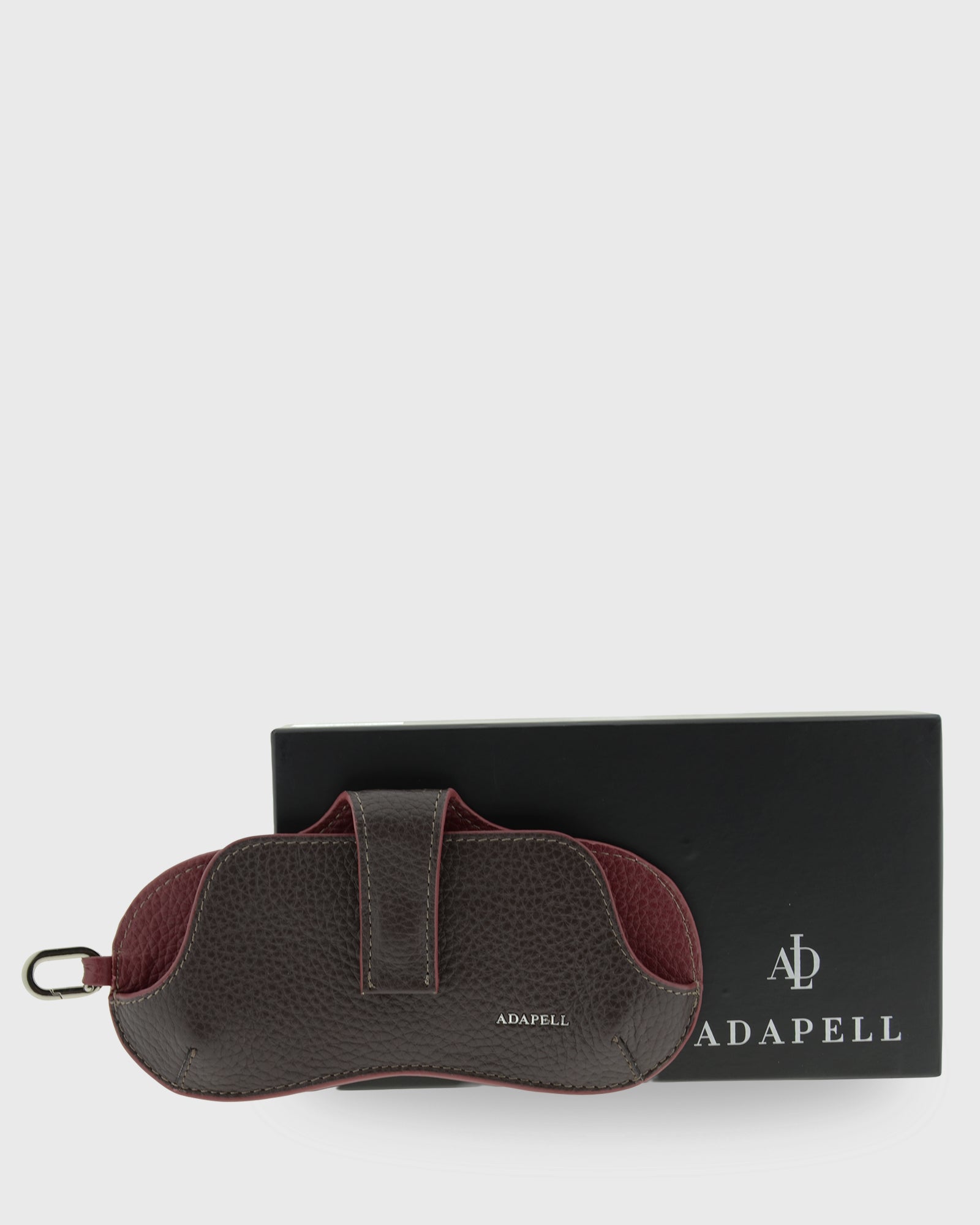 Vista frontal de la funda para gafas Nexo 8094 en color chocolate junto a su caja Adapell.