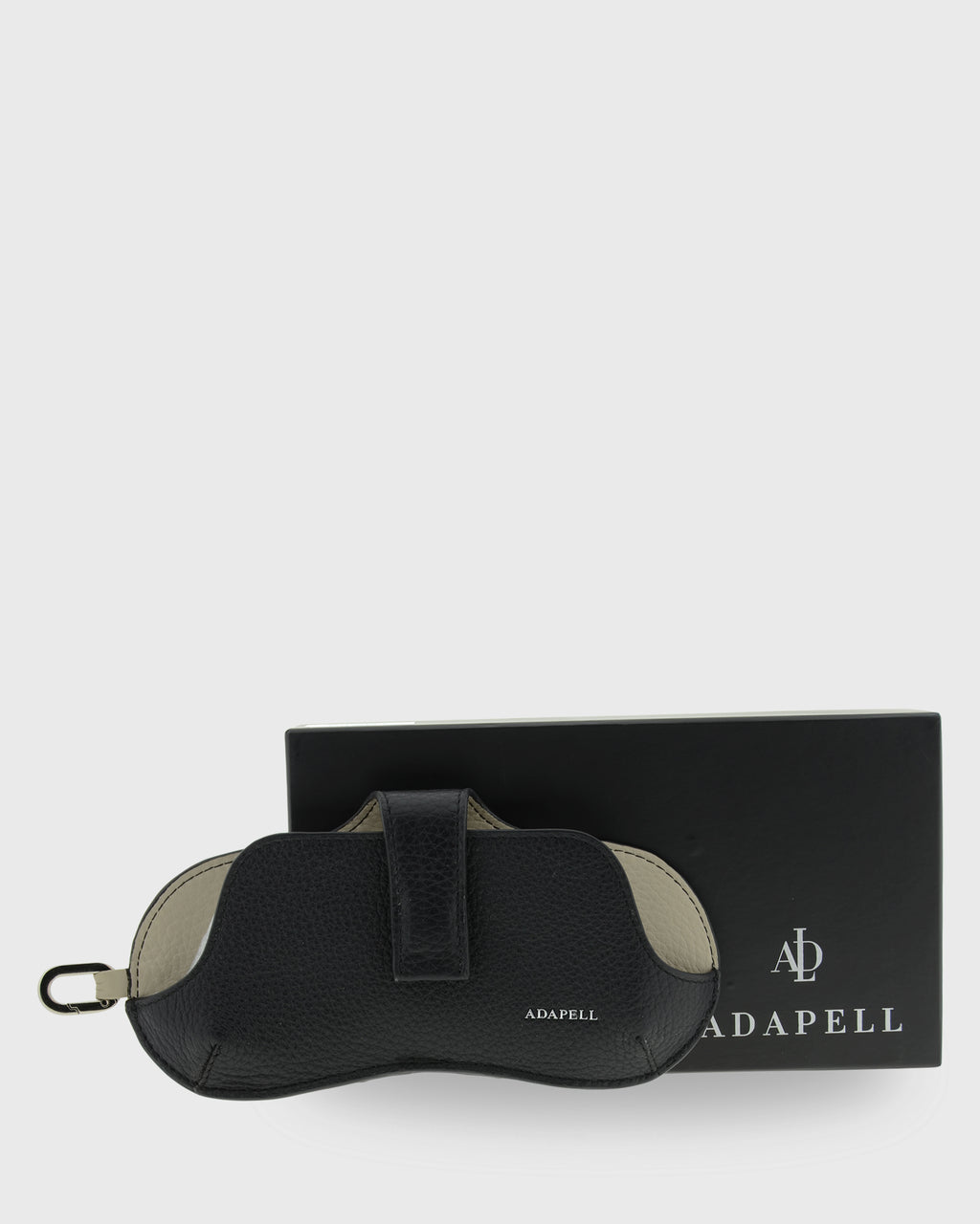 Vista frontal de la funda para gafas Nexo 8094 en color negro junto a su caja Adapell.