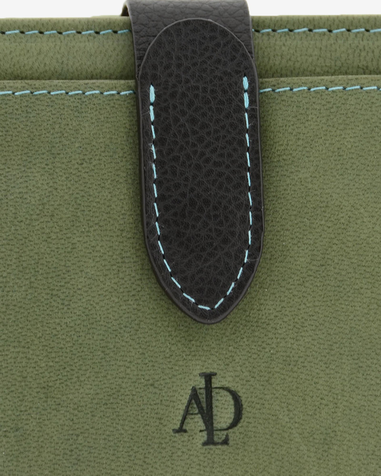 Detalle de cartera pequeña de piel color verde con acabado tipo nobuk, cierre negro en contraste y pespunte azul, 4198