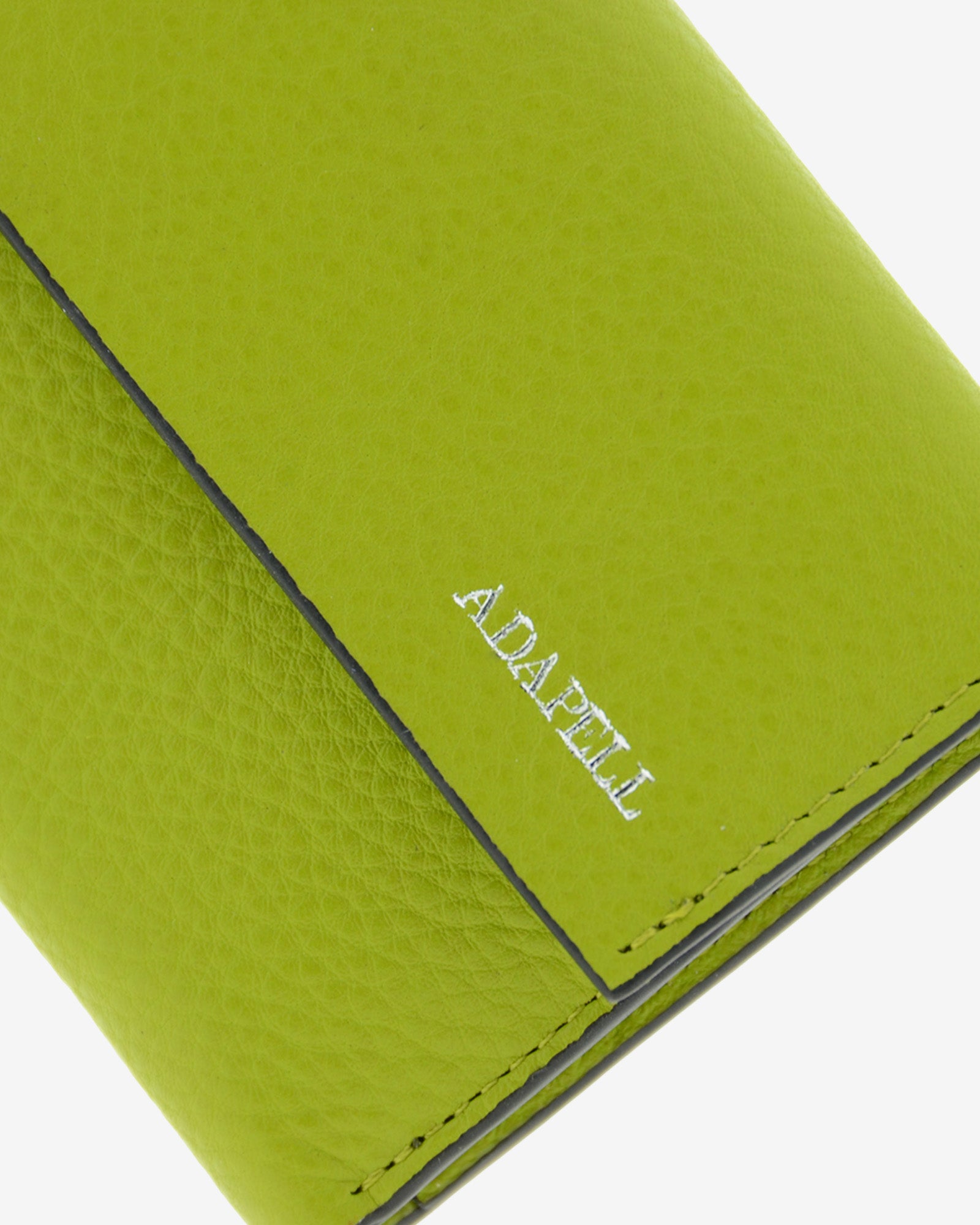 Cartera de piel auténtica ref. 8080-17 con solapa,  en color lima y ribete negro, de medida pequeña y compacta, con protección de tarjetas RFID de la colección Essenza, vista detalle de piel, ribete, costuras y logo Adapell