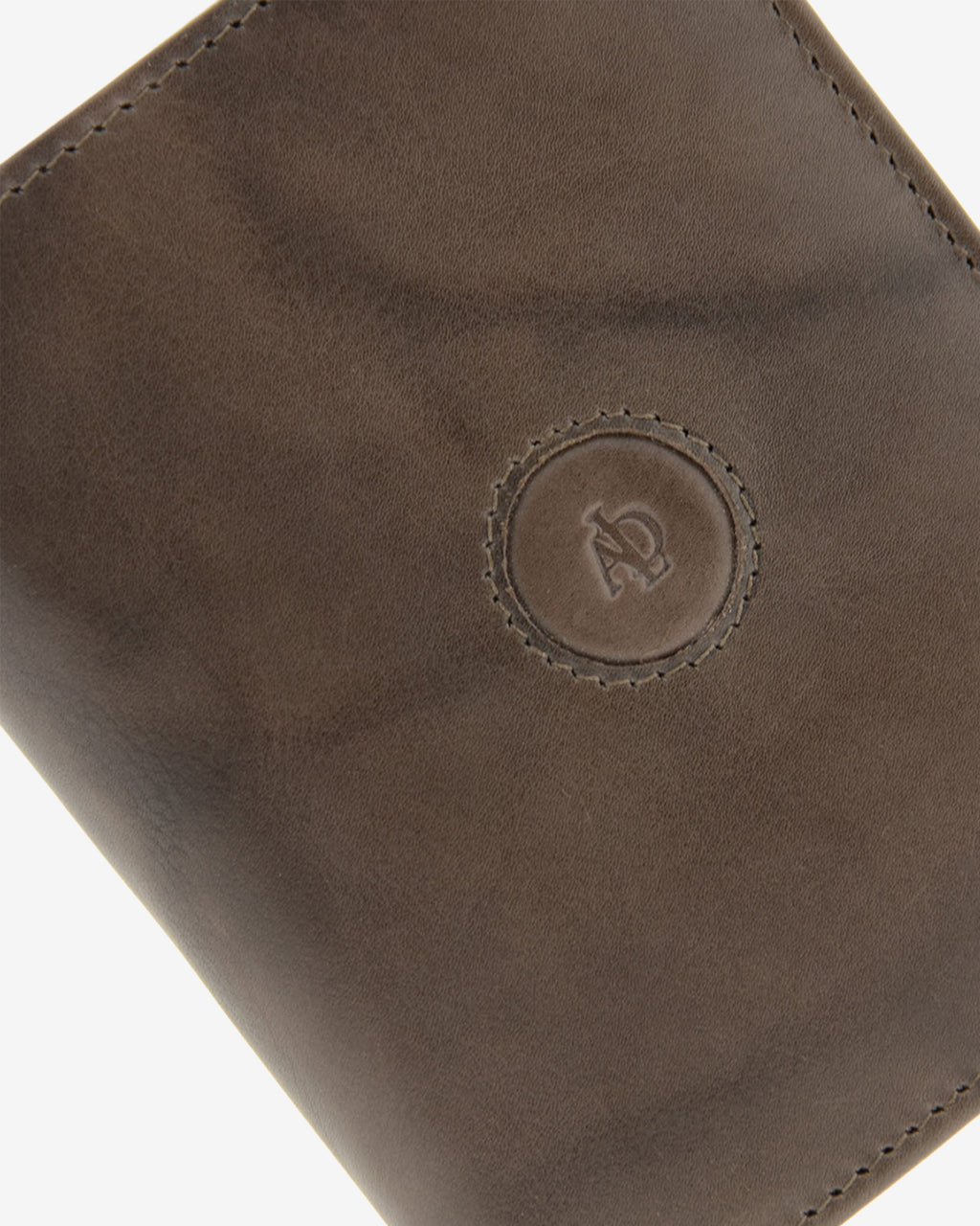 Detalle del logo circular en relieve, pespunte y textura de piel natural color gris en cartera Adapell, ref. 1592-11