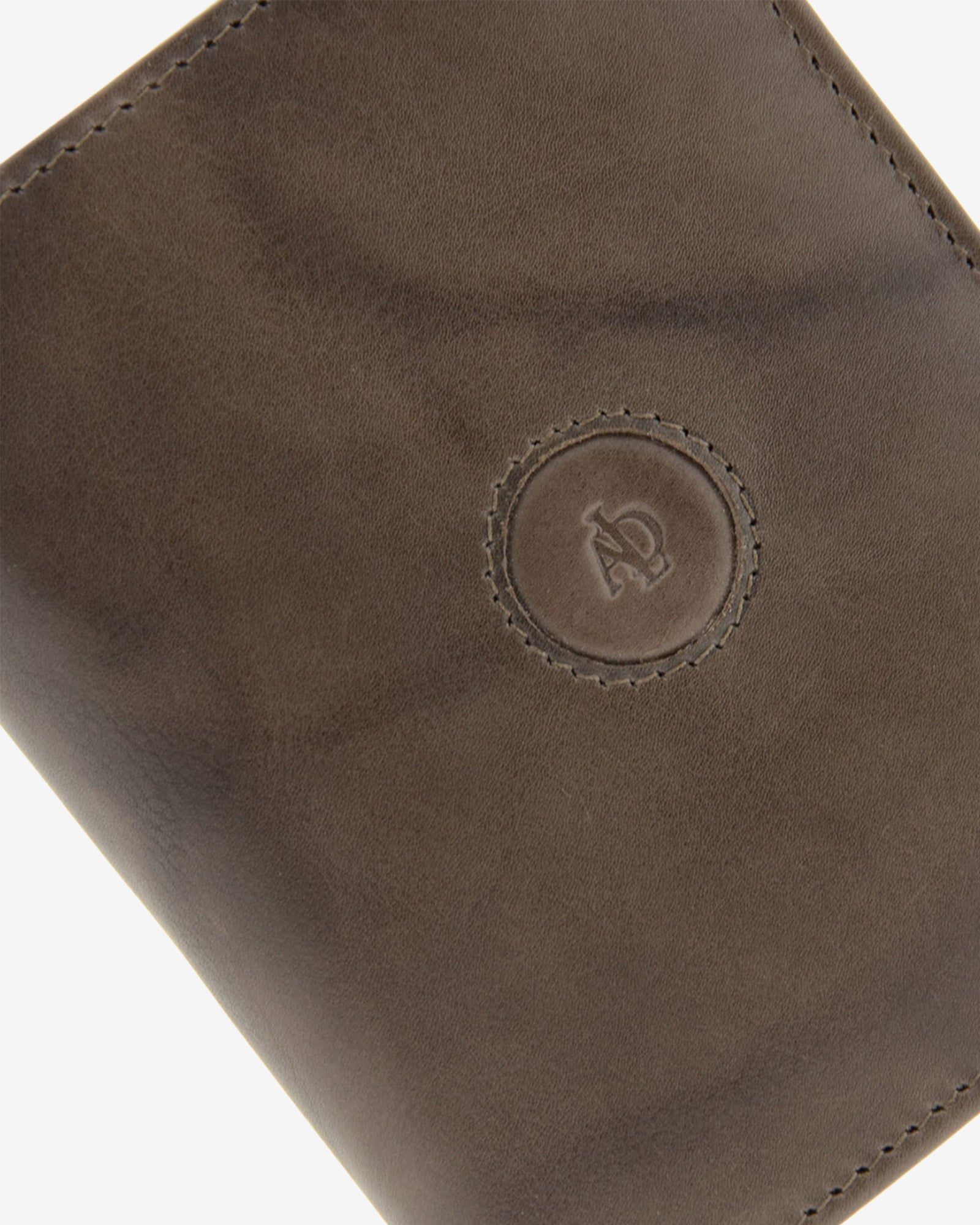 Detalle del logo circular en relieve, pespunte y textura de piel natural color gris en cartera Adapell, ref. 1592-11