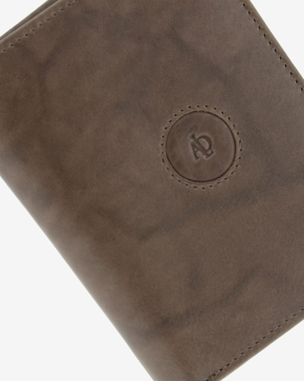 Detalle del logo circular en relieve, pespunte y textura de piel natural color gris en cartera Adapell, ref. 1591-11