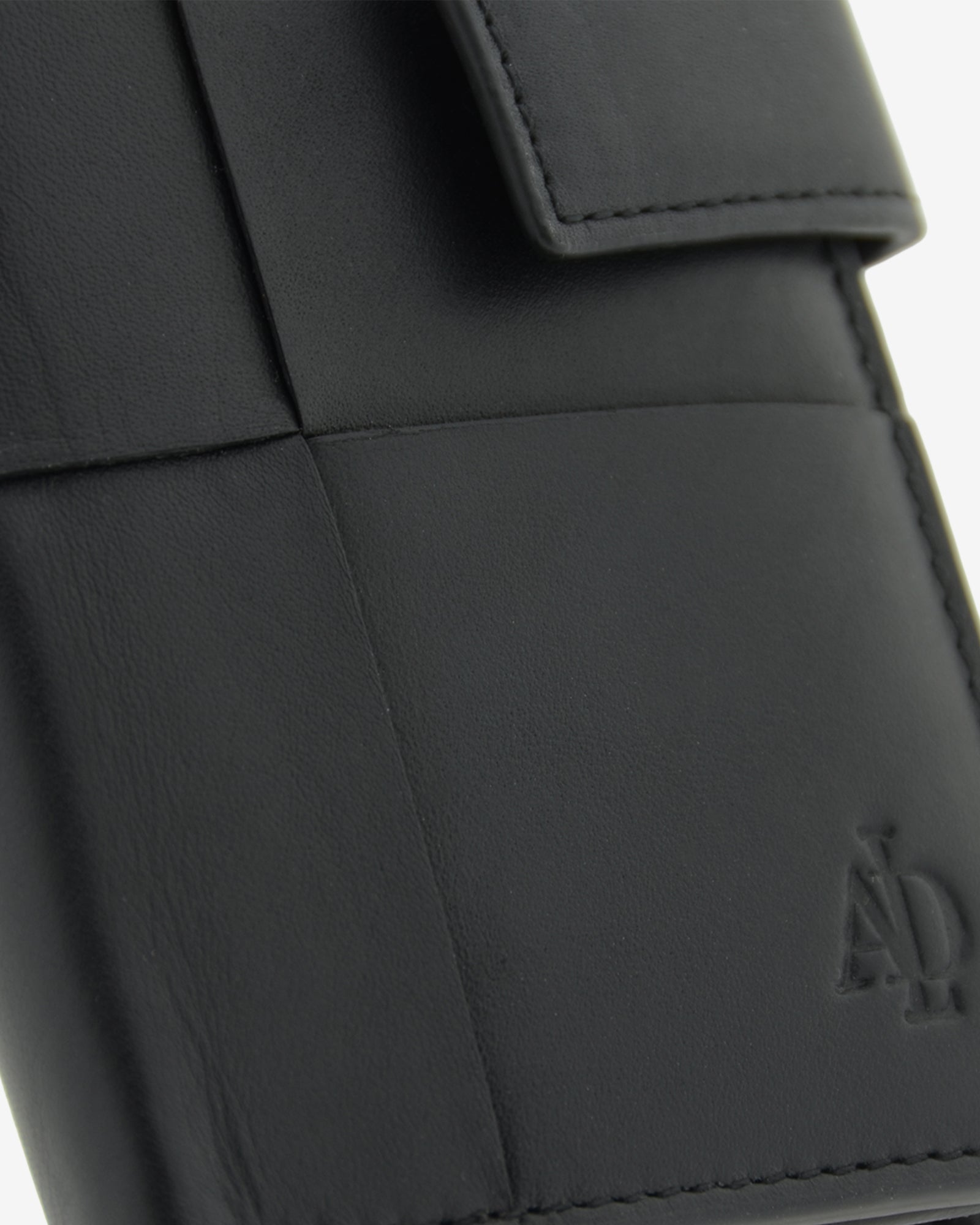 Detalle de piel y acabados en cartera vertical compacta color negro con cierre de botón, ref. 1666-1