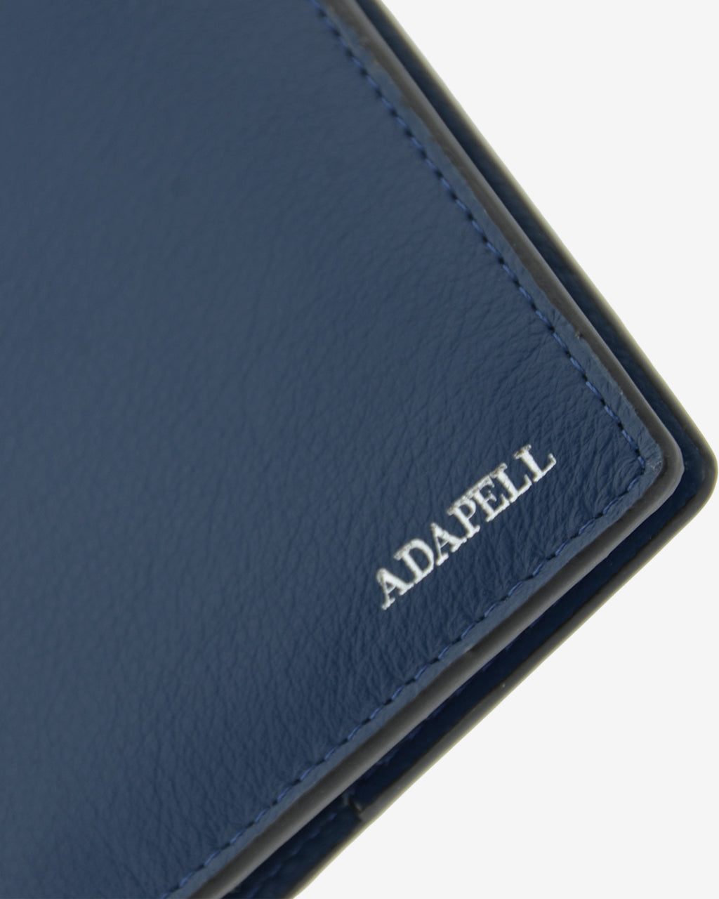 Funda pasaporte en piel auténtica muy suave de color azul marino y cantos en negro, ref. 8087-20, con protección RFID, y logo plateado Adapell, vista detalle de piel y acabados premium