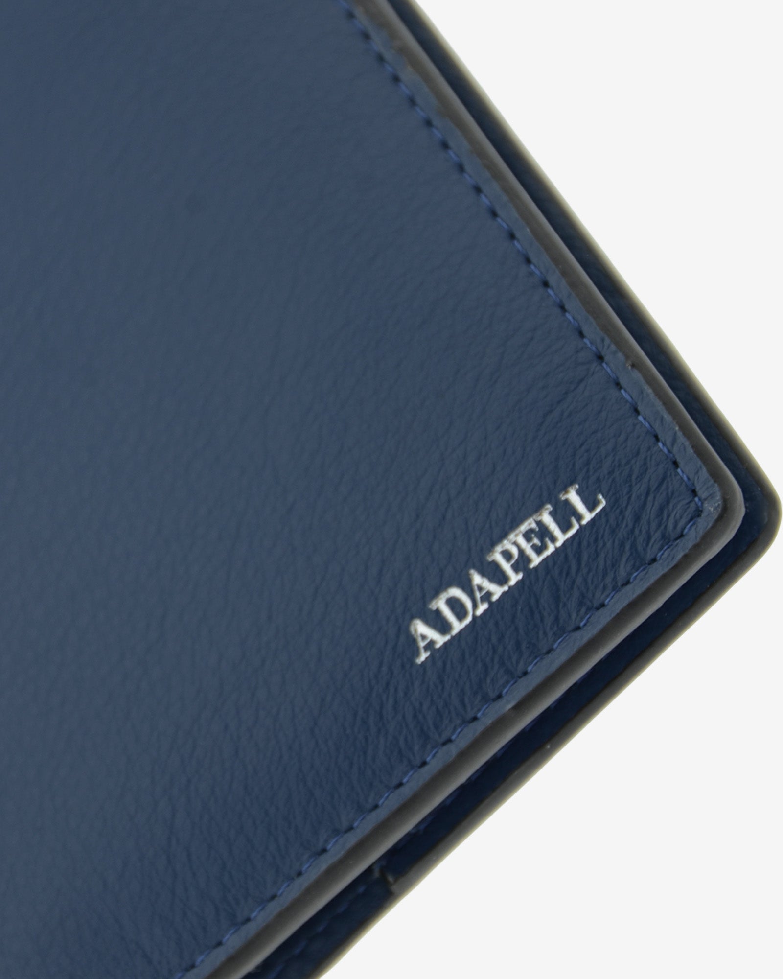 Funda pasaporte en piel auténtica muy suave de color azul marino y cantos en negro, ref. 8087-20, con protección RFID, y logo plateado Adapell, vista detalle de piel y acabados premium