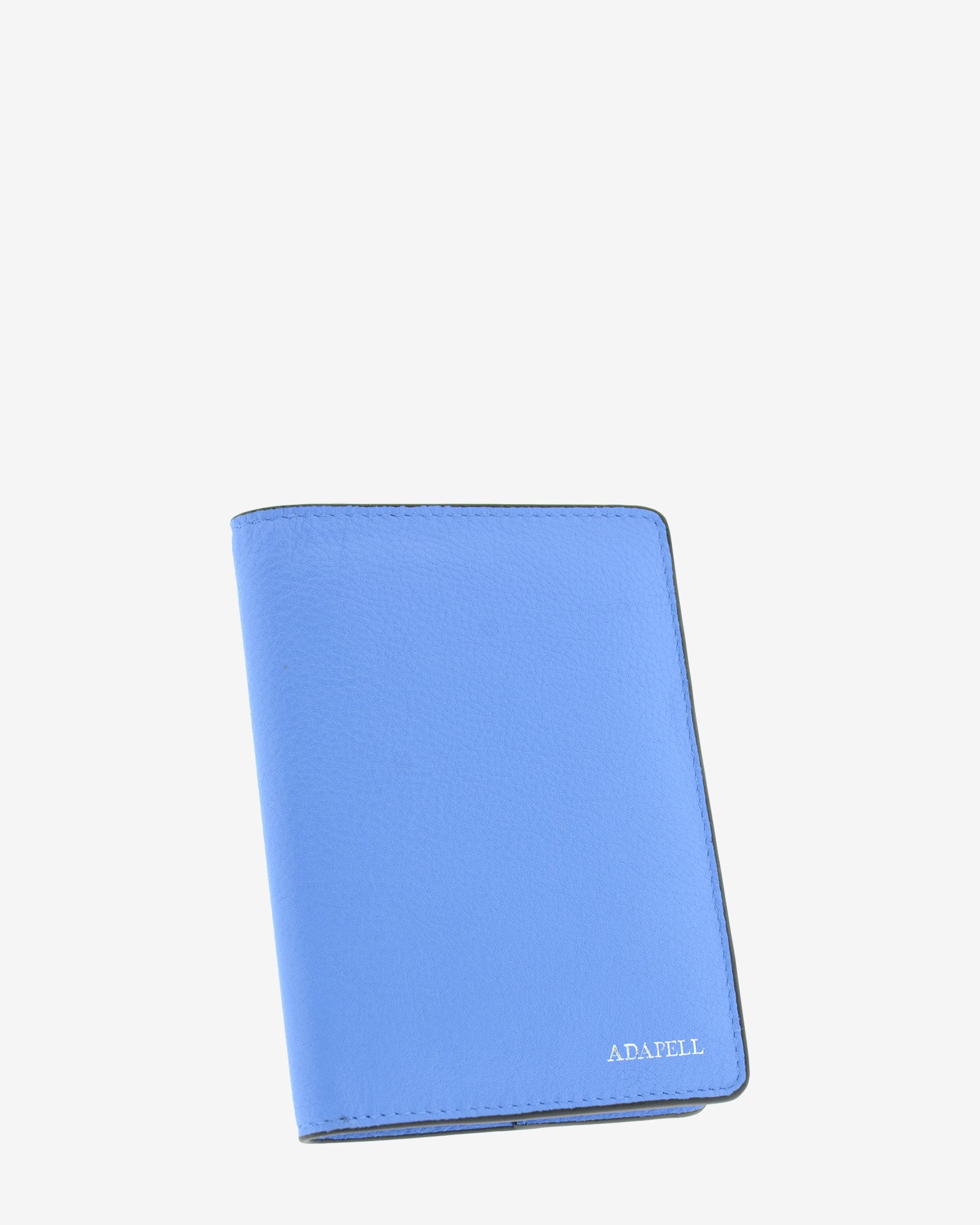 Funda pasaporte en piel auténtica muy suave de color azul y cantos en negro, ref. 8087-14, con protección RFID, y logo plateado Adapell, vista diagonal frontal