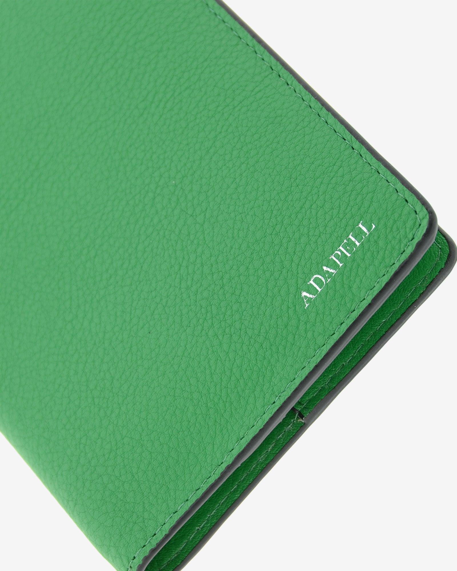 Funda pasaporte en piel auténtica muy suave de color verde y cantos en negro, ref. 8087-5, con protección RFID, y logo plateado Adapell, vista detalle de piel, acabados y logo Adapell