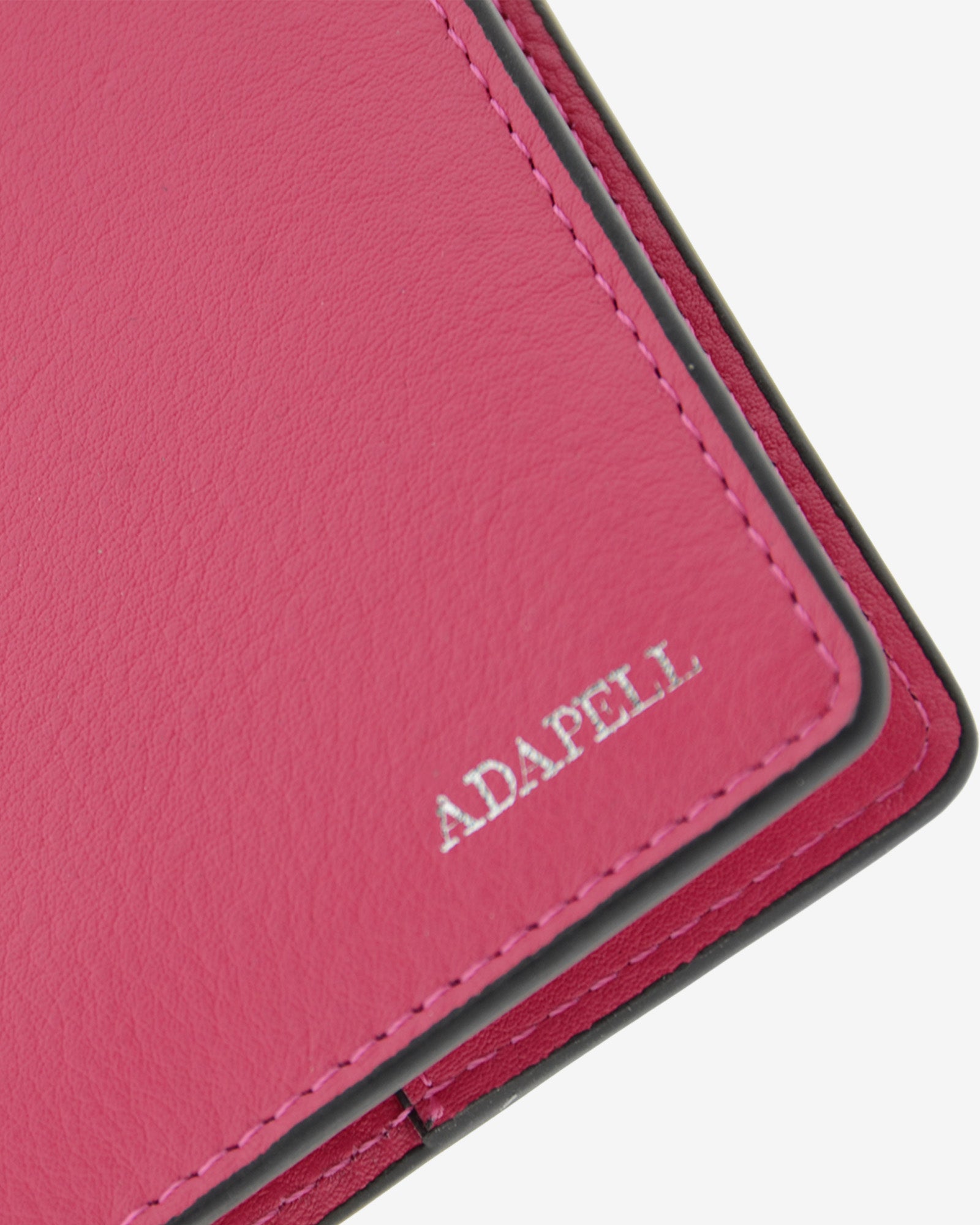 Funda pasaporte en piel auténtica muy suave de color fucsia y cantos en negro, ref. 8087-25, con protección RFID, y logo plateado Adapell, vista detalle de piel y acabados