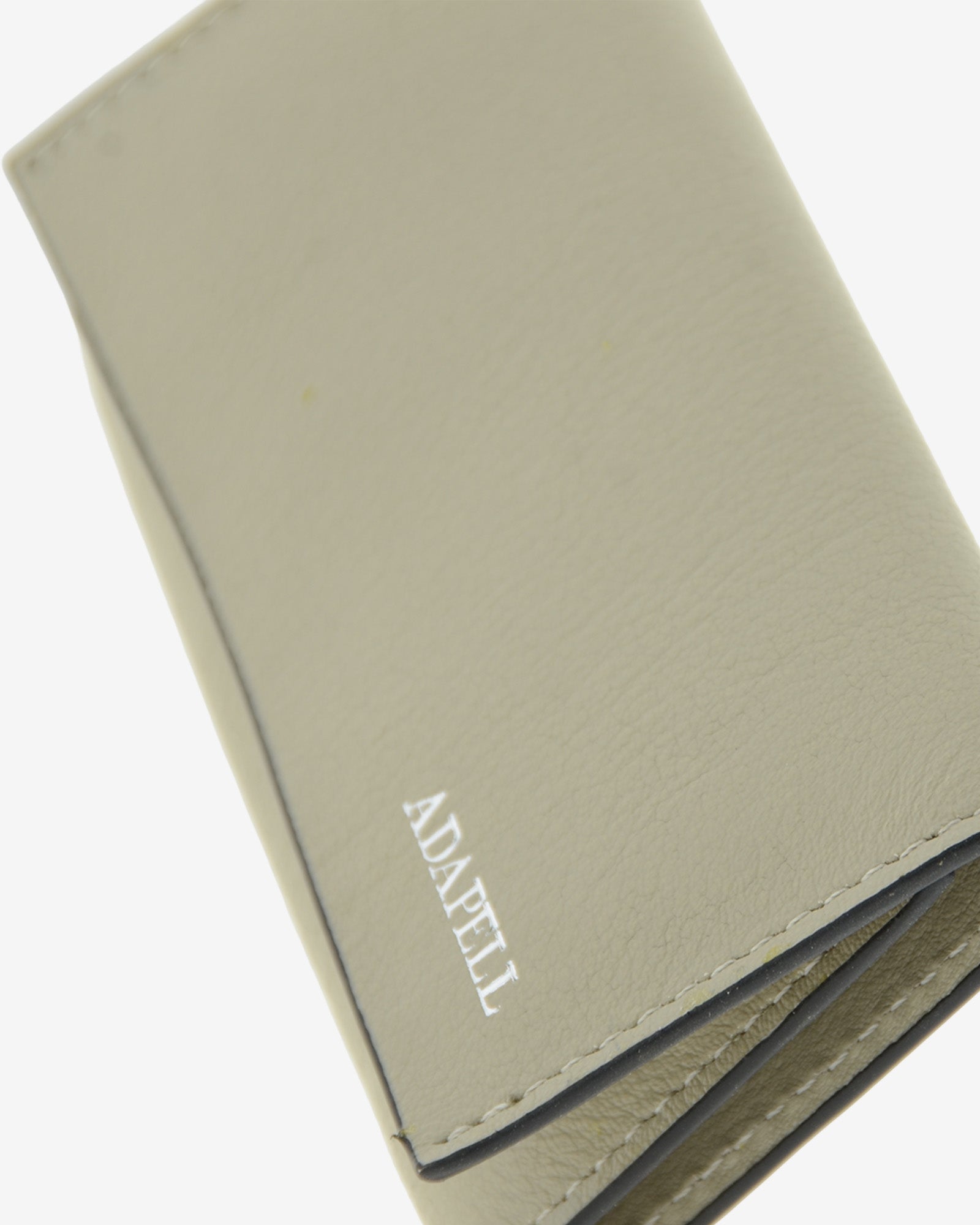 Llavero en piel auténtica de color ice stone, ref. 8084-12 y bordes en negro, con interior de piel, mosquetón para 6 llaves y exterior con compartimento para tarjeta, vista detalle de piel, acabados de lujo y logo Adapell