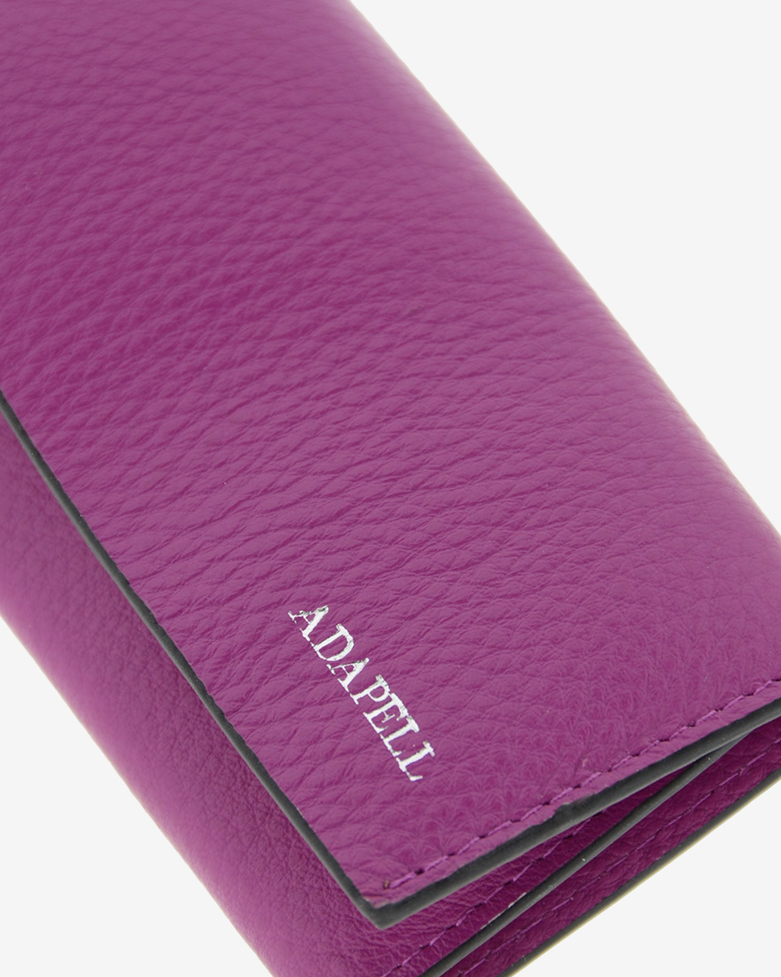 Llavero en piel auténtica de color lila y bordes en negro, con interior de piel, mosquetón para 6 llaves y exterior con compartimento para tarjeta, vista detalle piel, acabados y logo Adapell