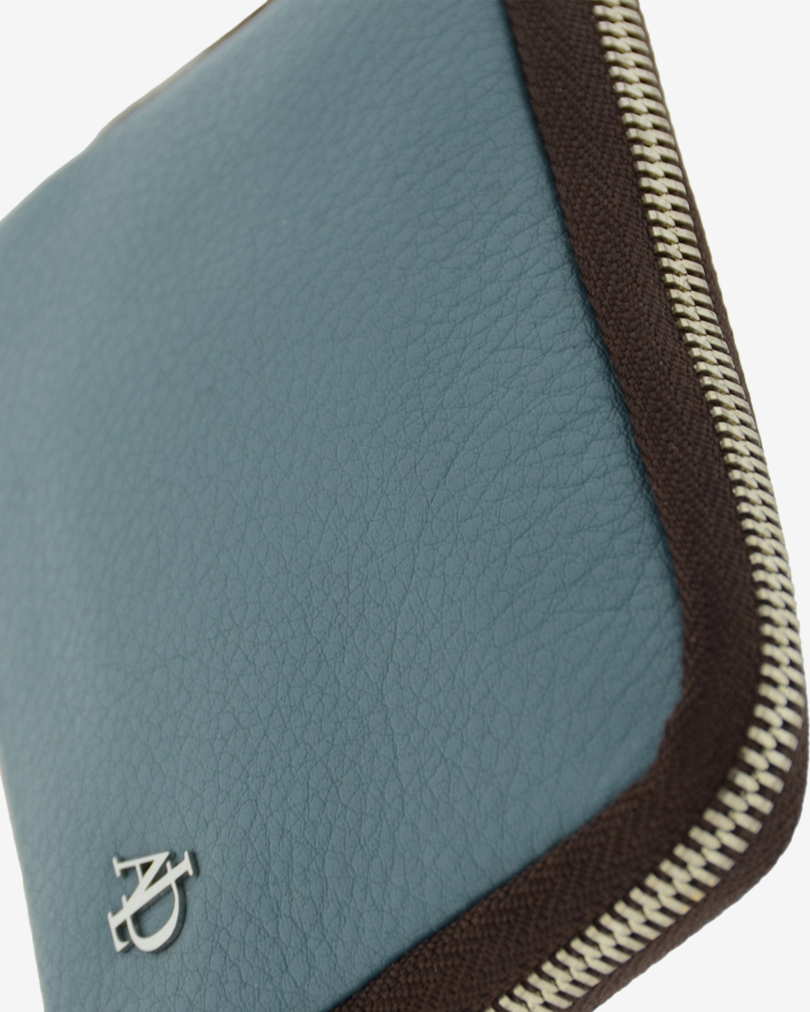 Detalle del monedero de piel color azul con logo metalico y cremallera superior – Adapell Ref. 4248-14.