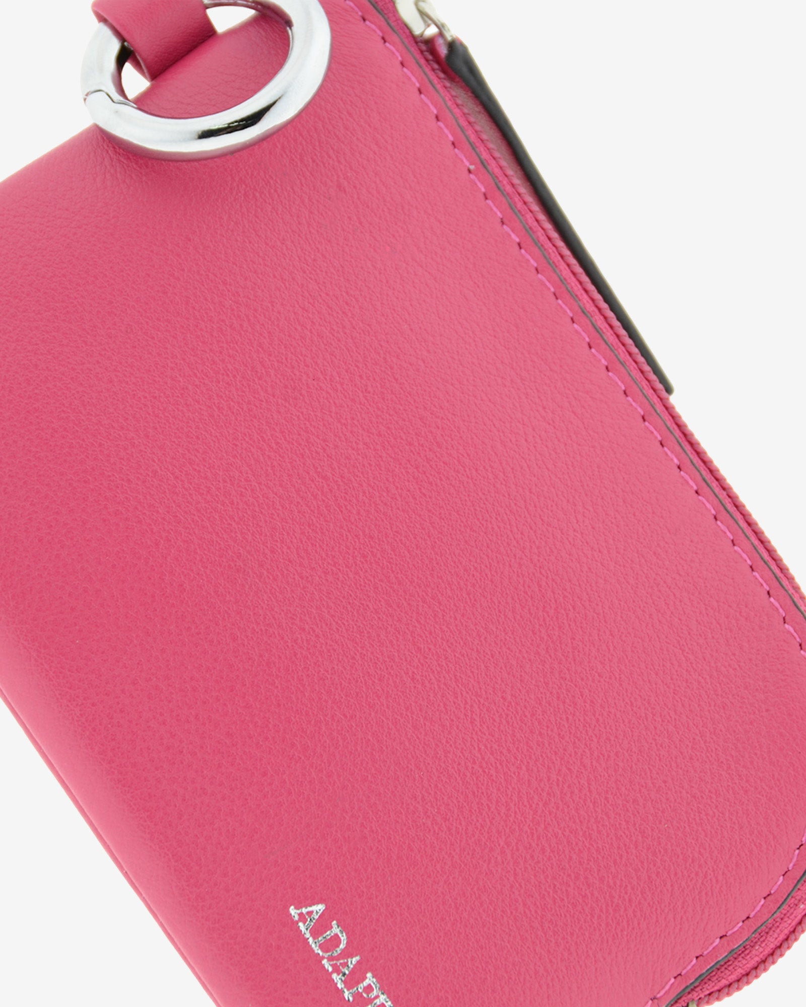 Monedero de piel auténtica ref. 8081-25 en color fucsia con ribete negro, de medida pequeña y compacta, cierre de cremallera y aro metálico exterior, con protección de tarjetas RFID de la colección Essenza, vista detalle de piel, acabados y logo Adapell