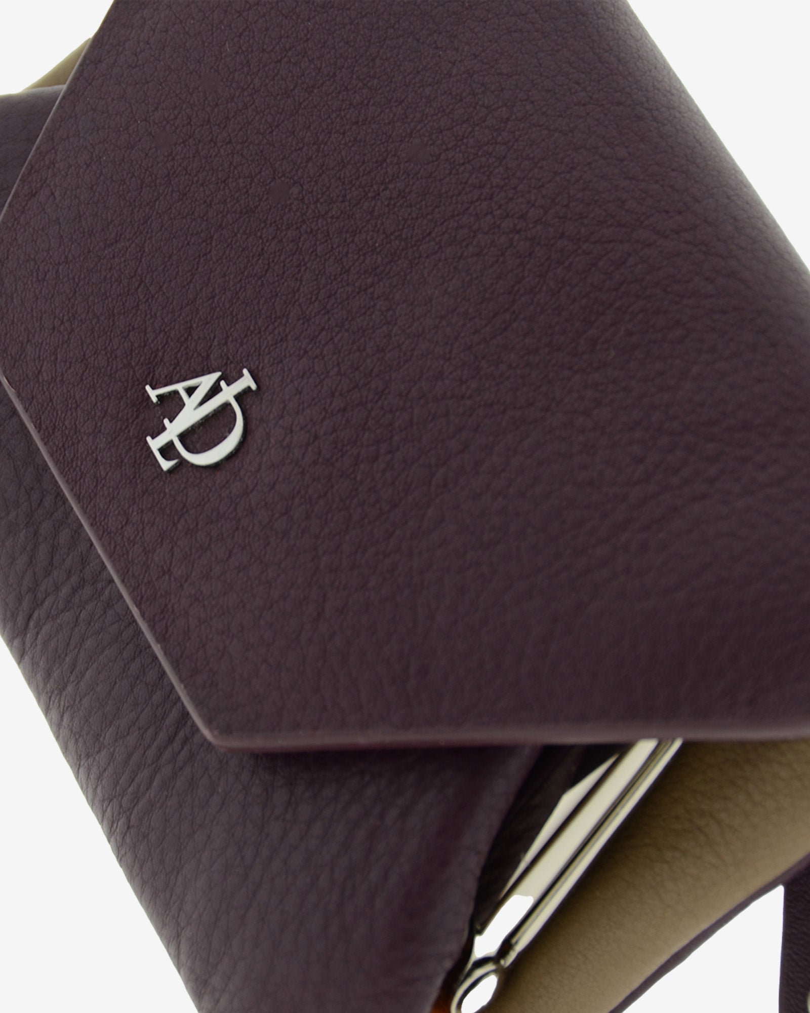Monedero de piel autentica para mujer en color berenjena, con boquilla interior. Vista  detalle piel y logo Adapell.