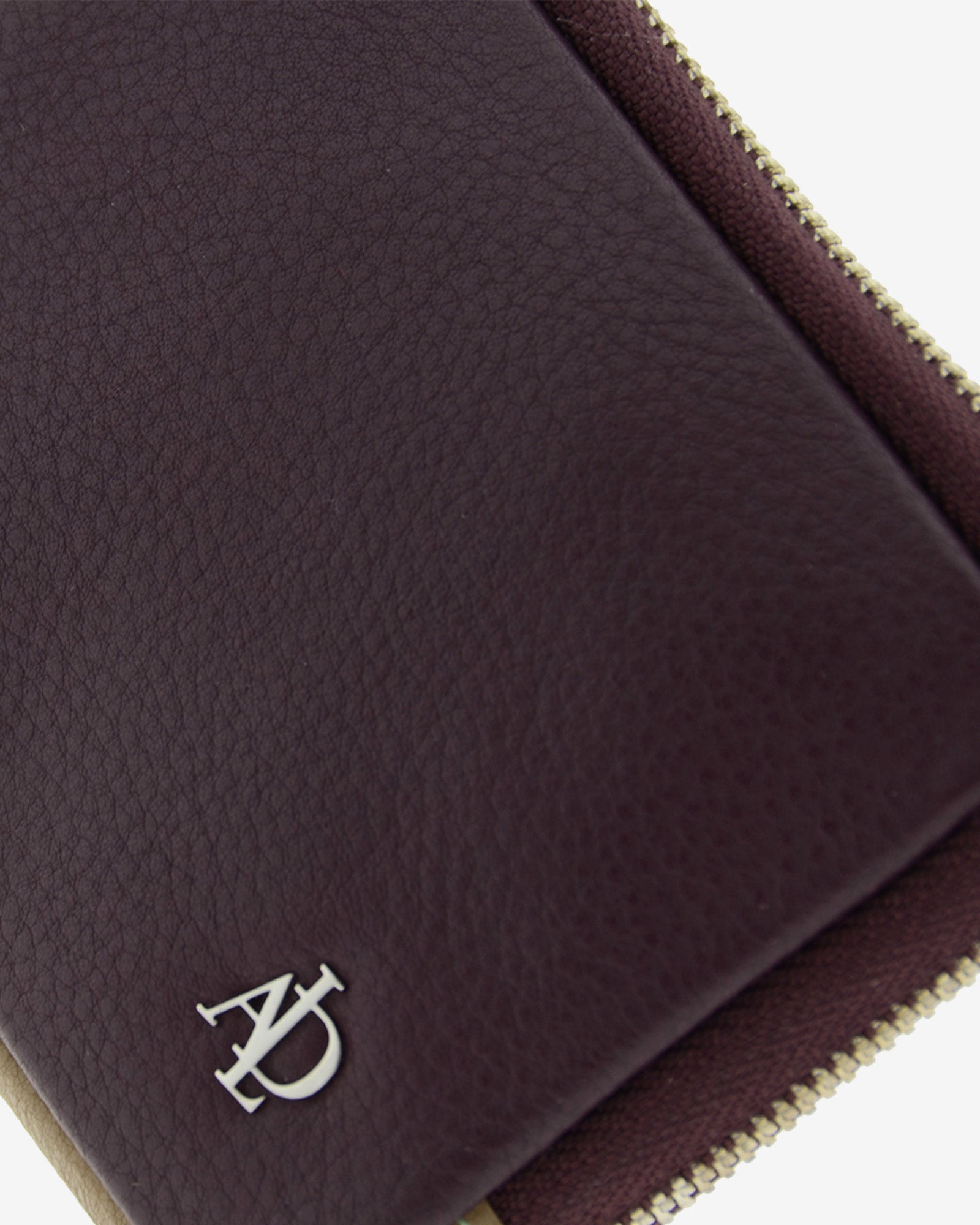 Monedero de mujer en piel de color berenjena, con cremallera metálica y logo Adapell. Ref. 4241-19. Vista detalle piel y logo metalico.