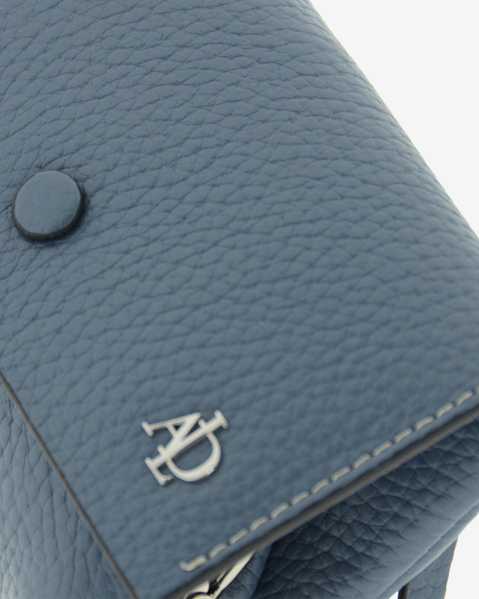 Monedero de mujer en piel auténtica granulada de color azul blue stone, con boquilla interior y protección de tarjetas RFID. De la colección Nude, vista detalle de piel, costuras y logo Adapell