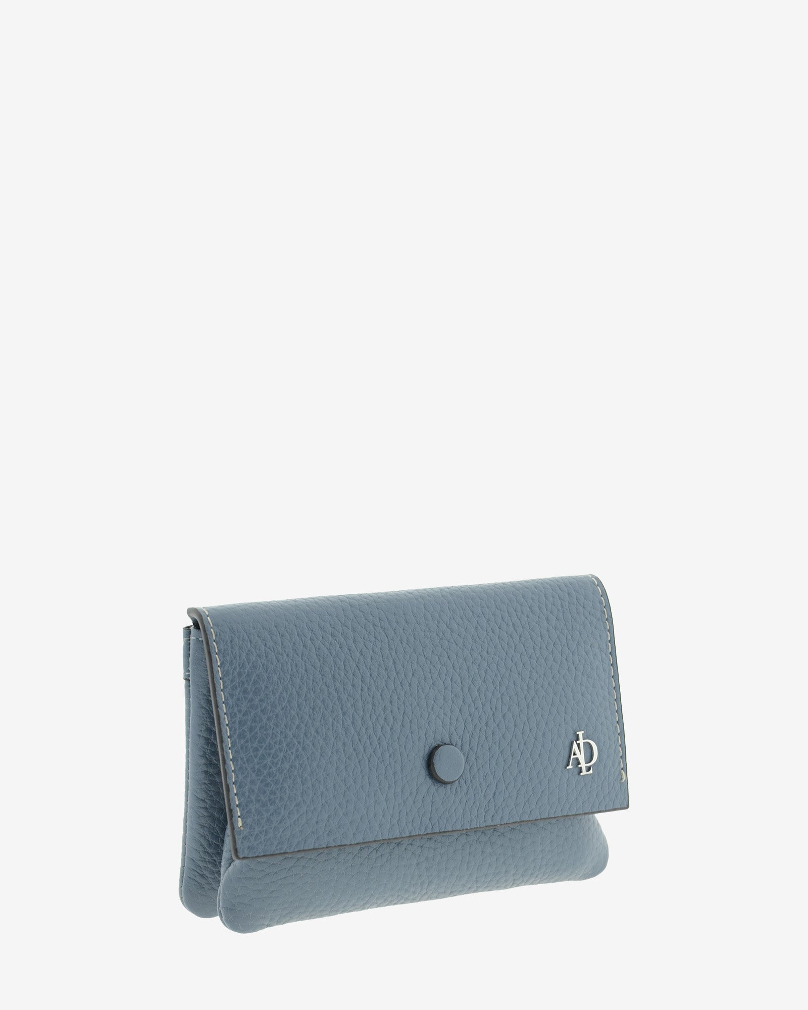 Monedero de mujer en piel auténtica granulada de color azul blue stone, con boquilla interior y protección de tarjetas RFID. De la colección Nude, vista diagonal frontal.